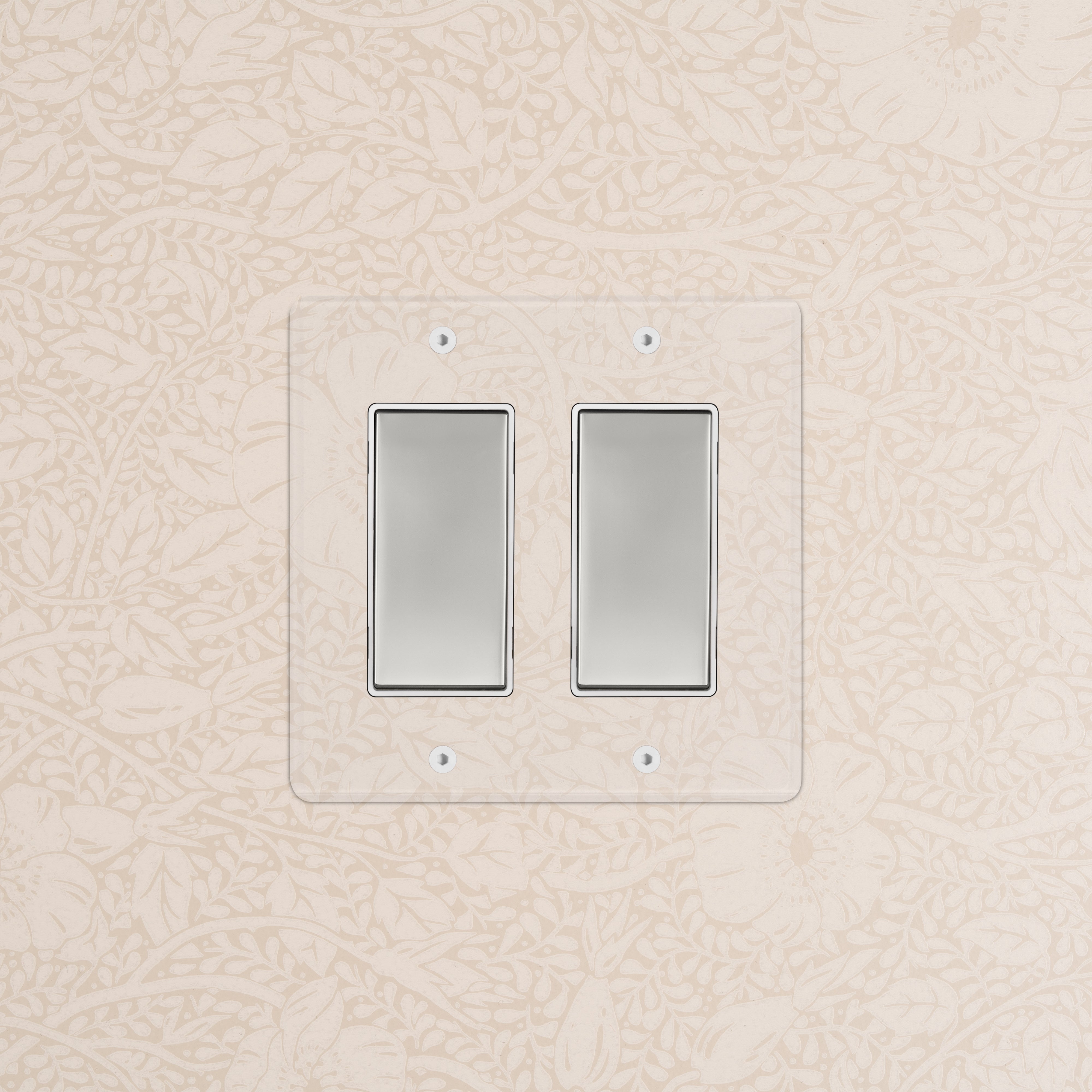Kew 2G Rocker Switch in clear polished nickel white finish, installed on a wall with floral wallpaper.