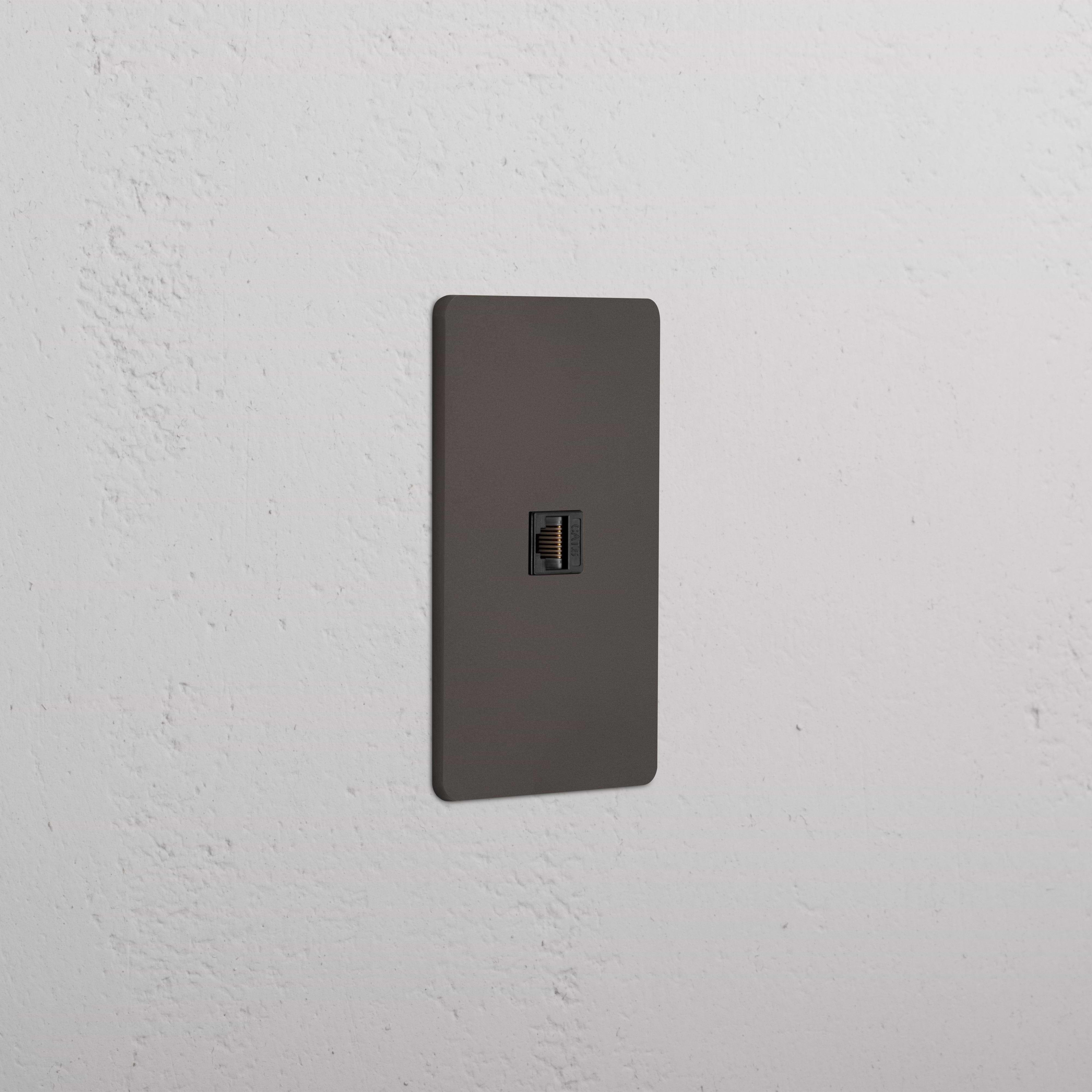 Grove 1G CAT 6 Keystone Ethernet jack with Bronze Black faceplate, mounted on a white wall.