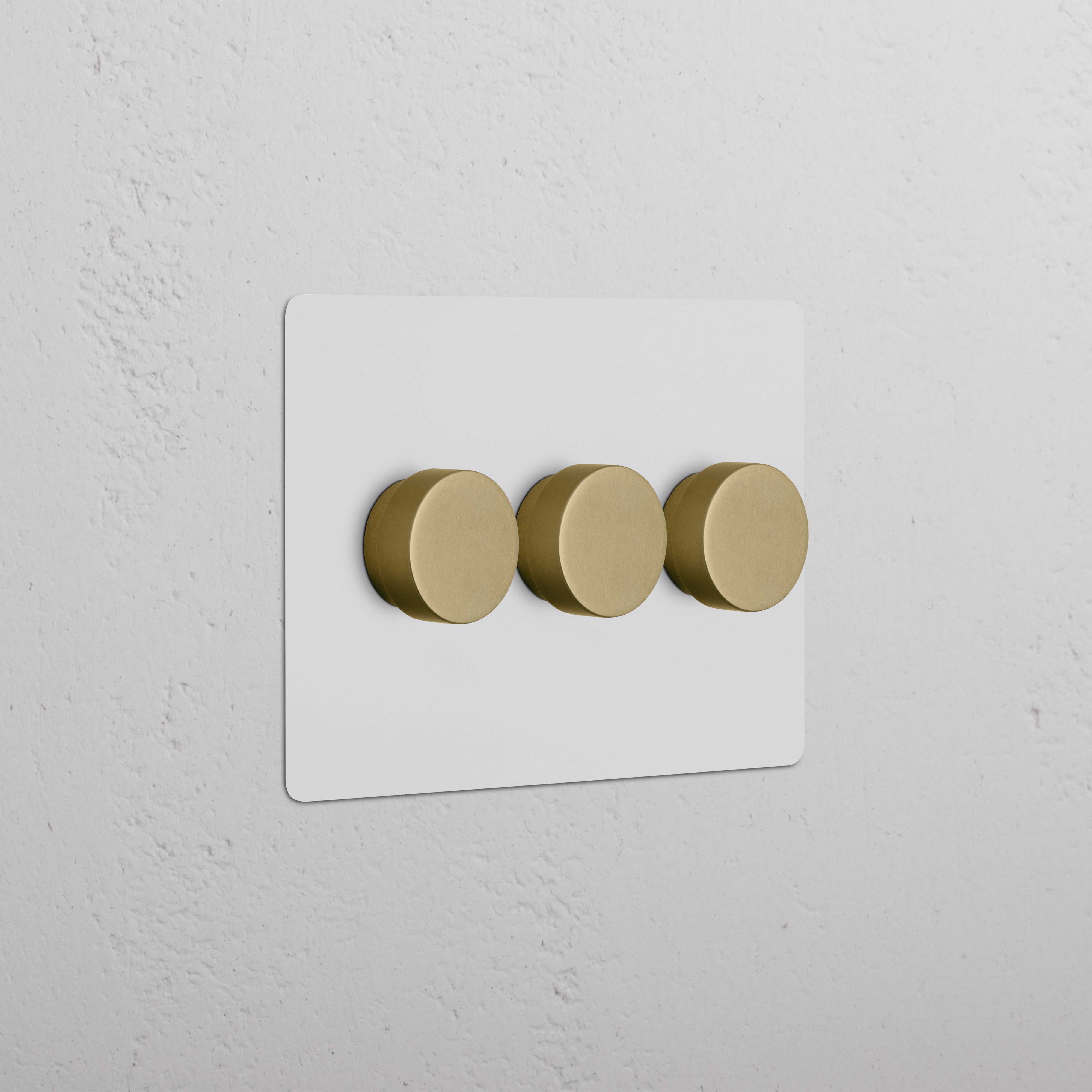 Kew 3G Dimmer Switch in paintable antique brass finish with three round knobs on a white plate.