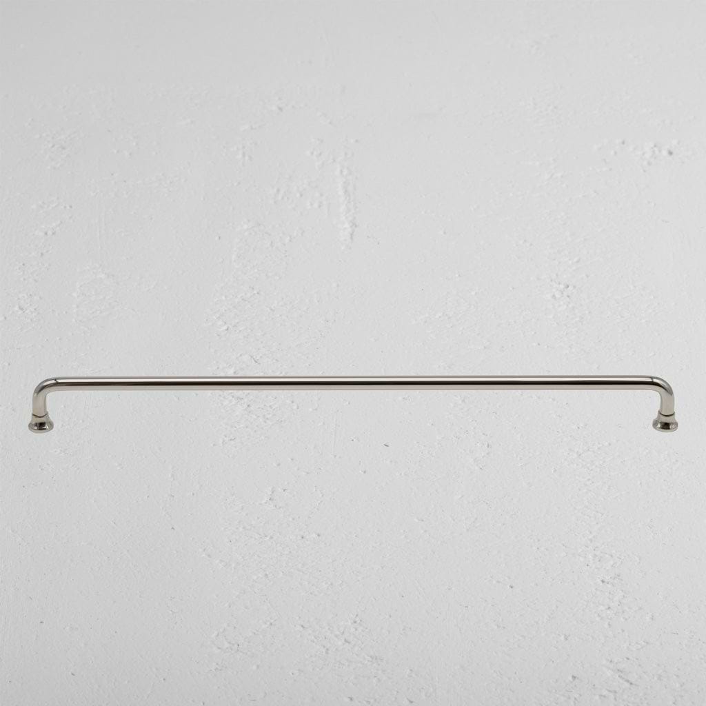 Large Sycamore furniture handle in polished nickel finish, mounted horizontally on a light wall.