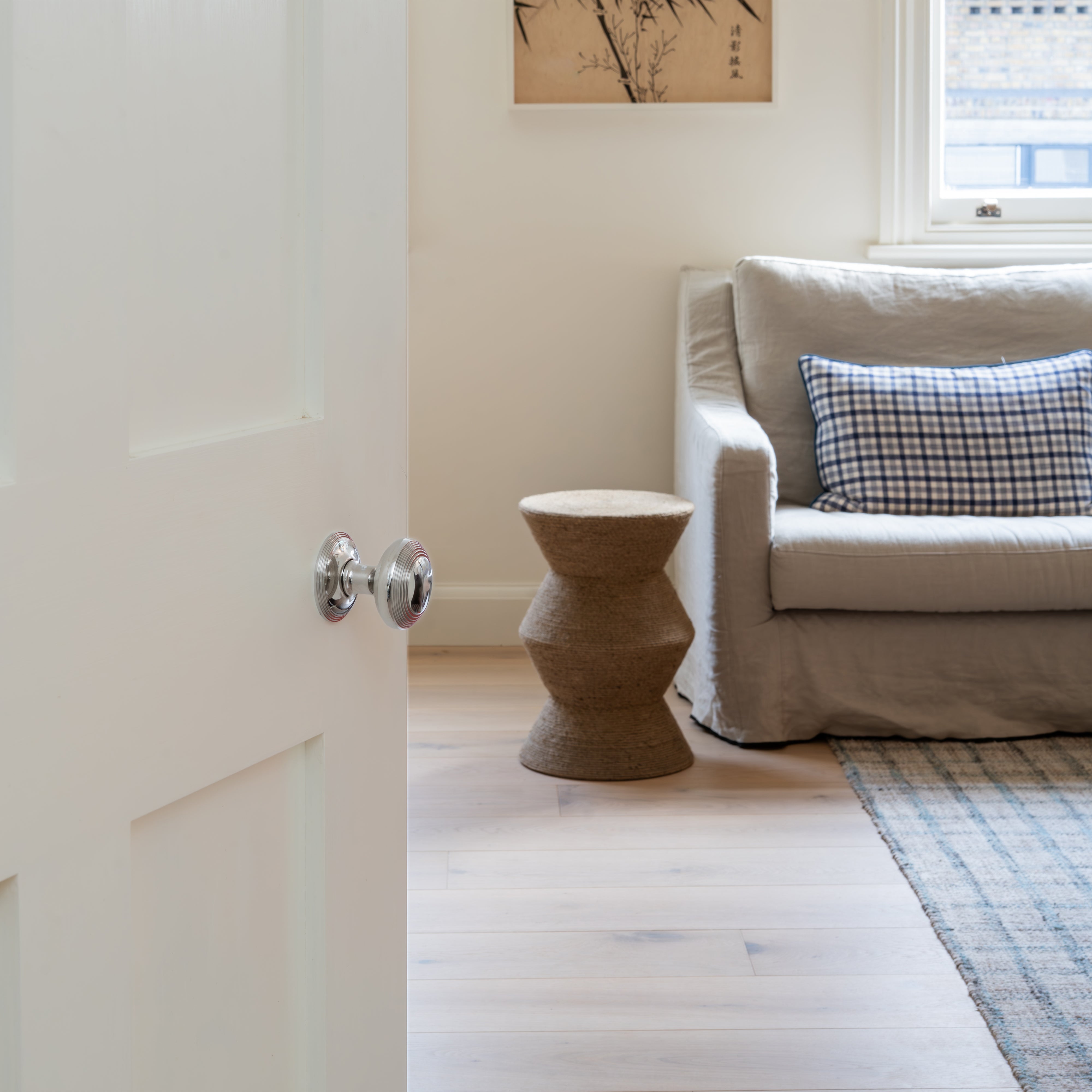 Polished nickel Poplar Dummy Door Knob Set installed on a white interior door.