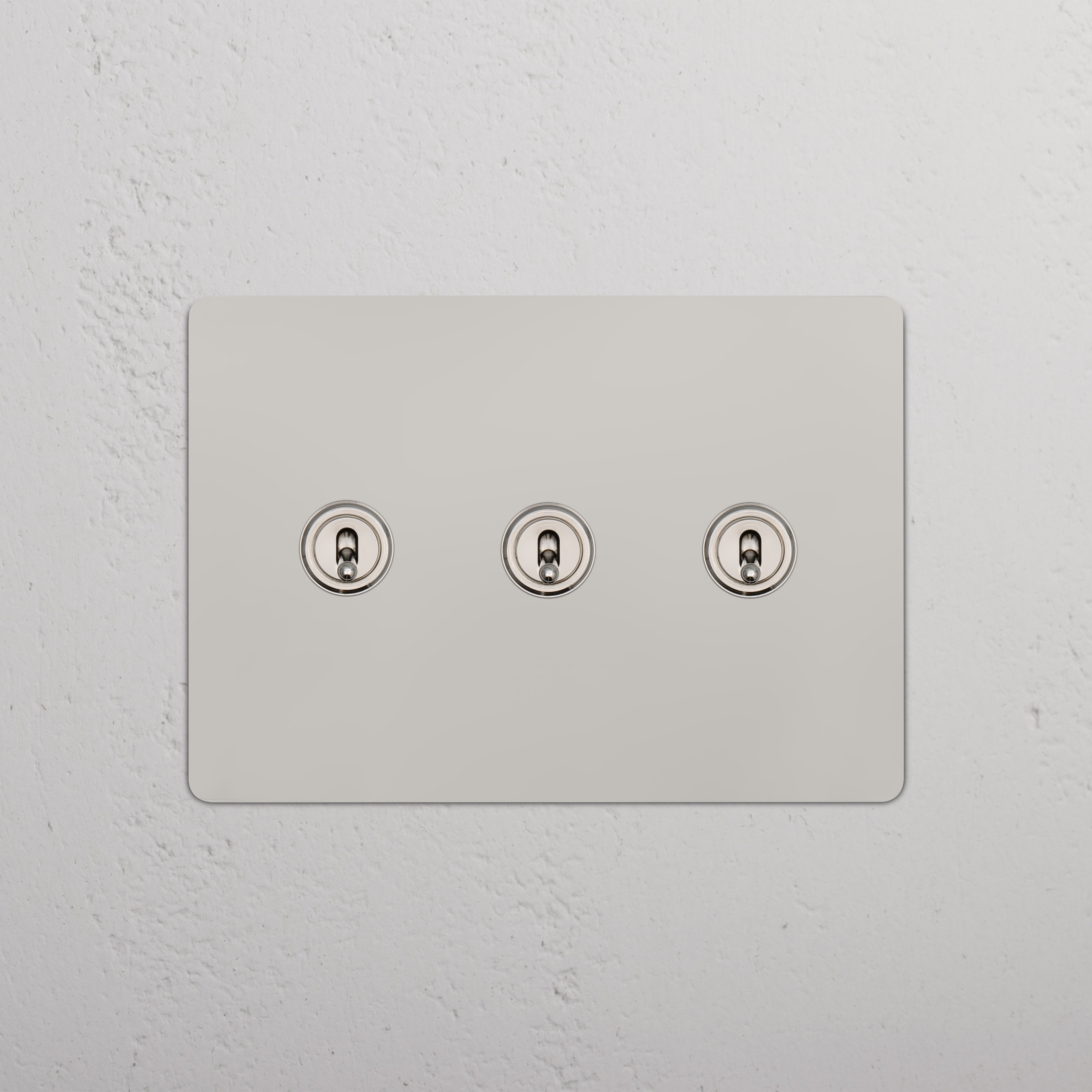 Kew 3G Toggle Switch in polished nickel finish with three round toggles on a rectangular wall plate.