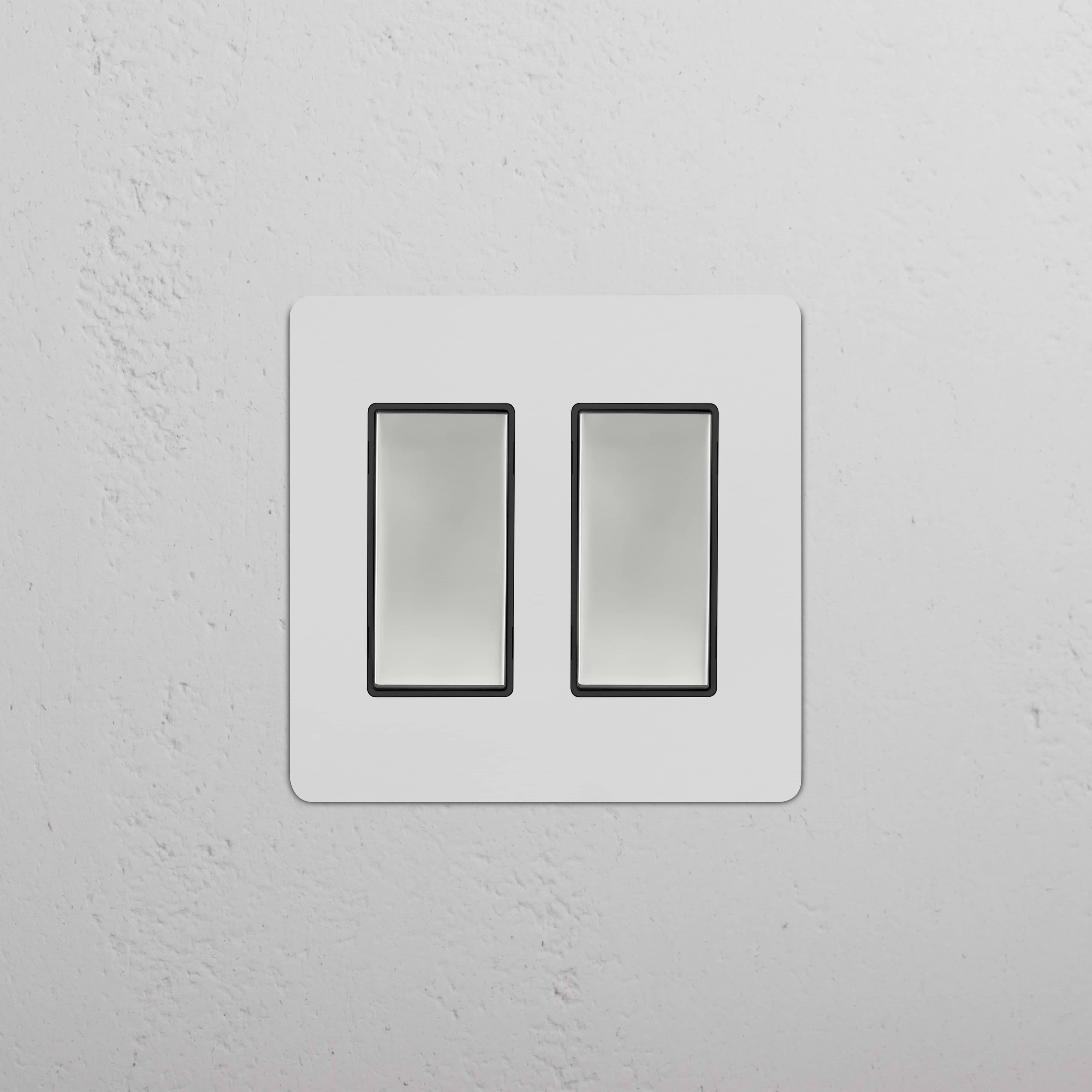 Kew 2G Rocker Switch in paintable polished nickel black finish with two rectangular switches on a wall.