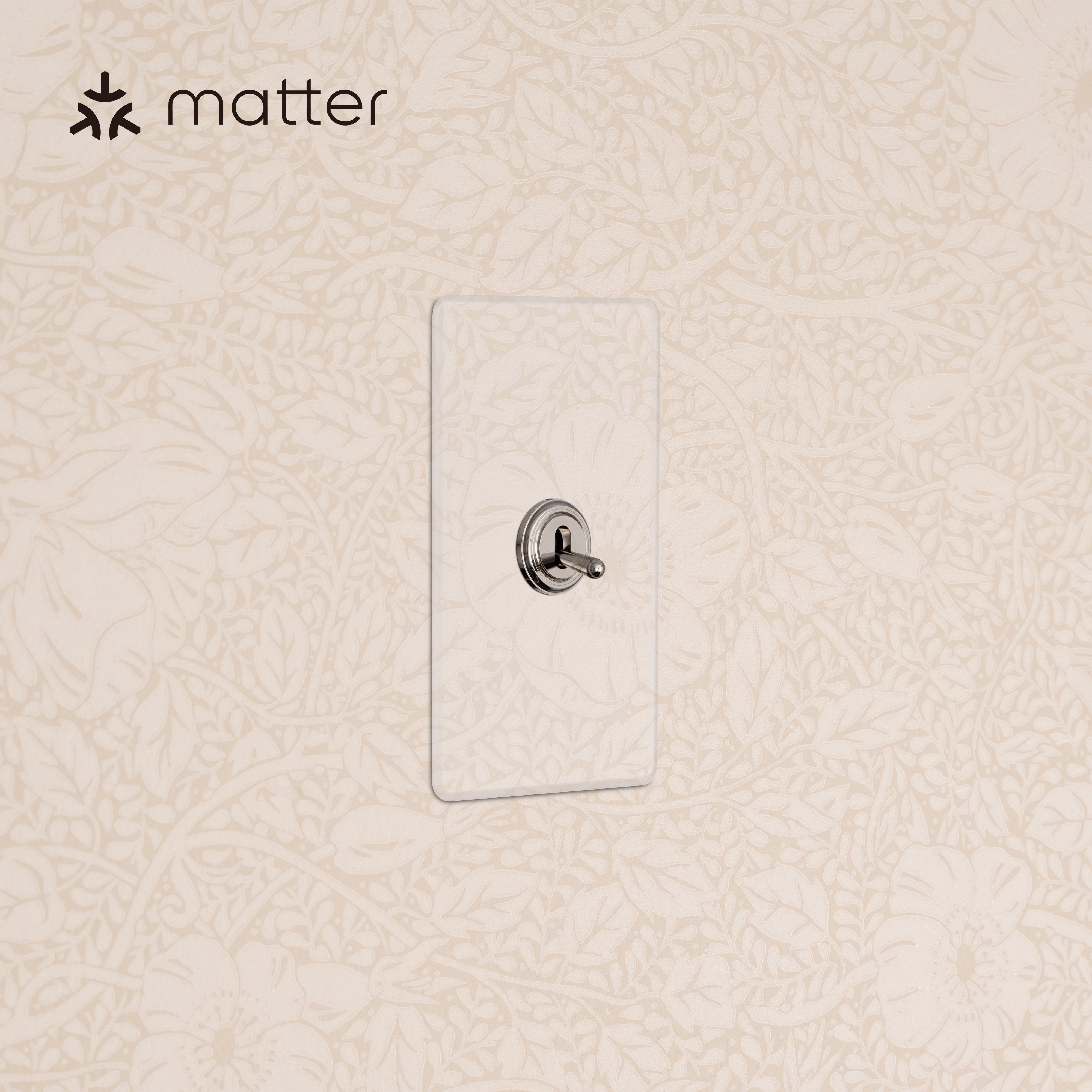 Kew 1G Smart Retractive Toggle Switch in clear polished nickel, mounted on a wall with floral wallpaper.