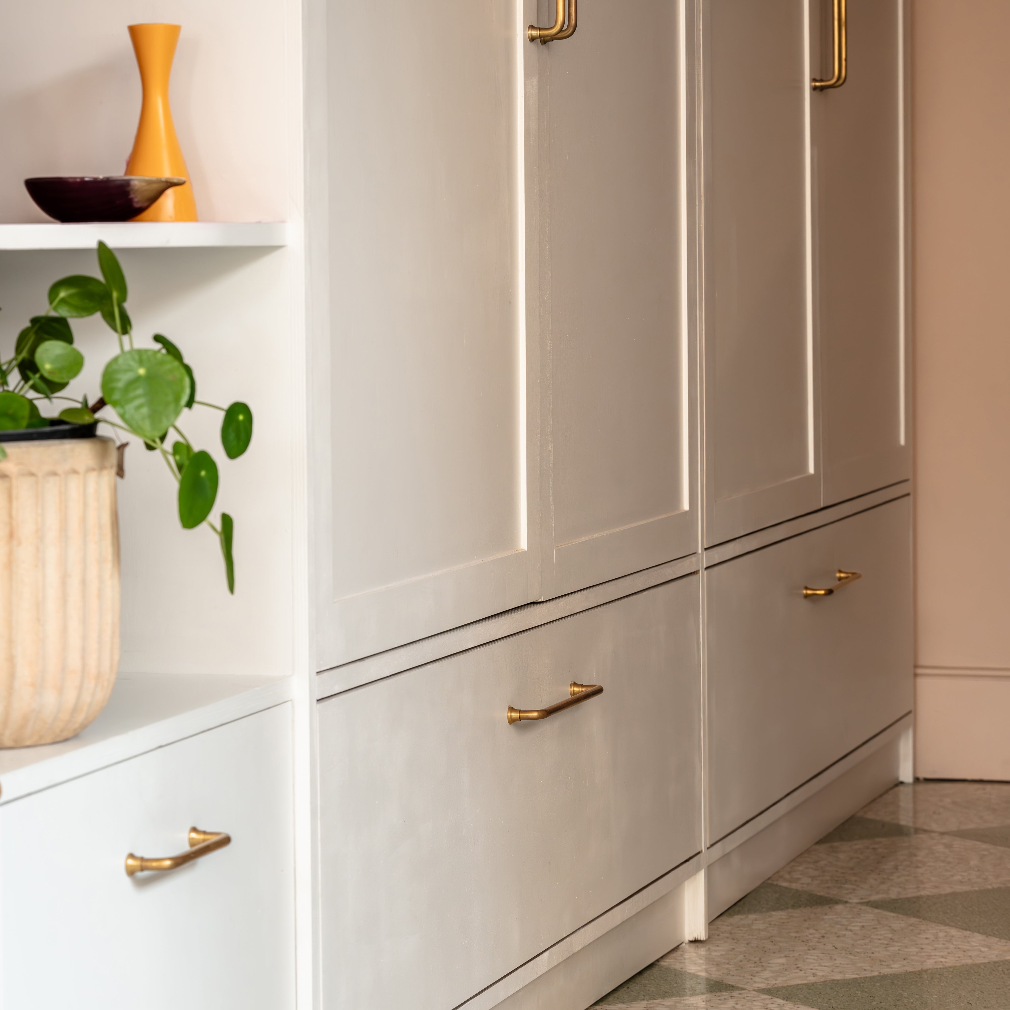 Sycamore Furniture Handle Small in Antique Brass fitted to a white cabinet drawer front.
