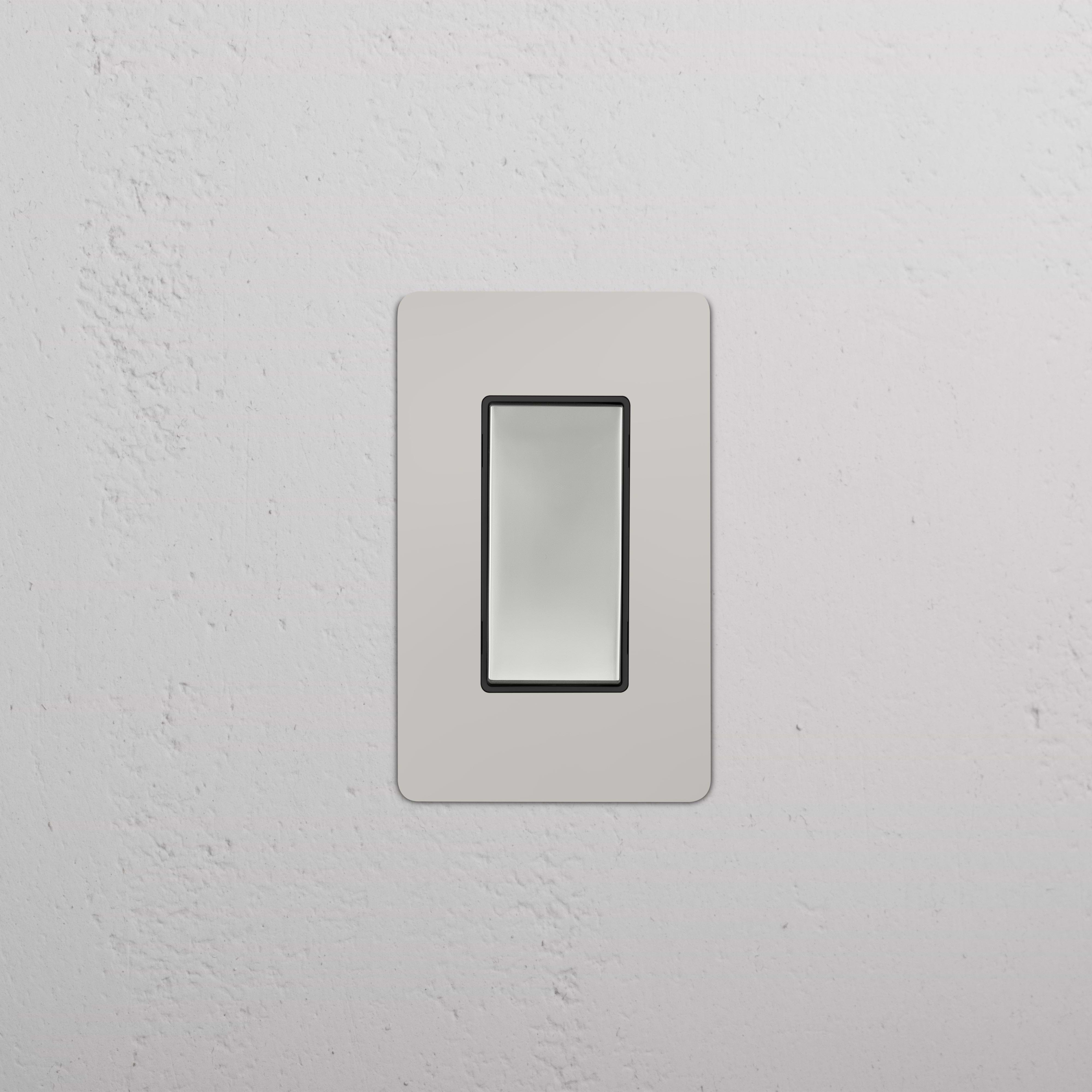Kew 1G Retractive Rocker Switch in polished nickel with black trim, installed on a white textured wall.