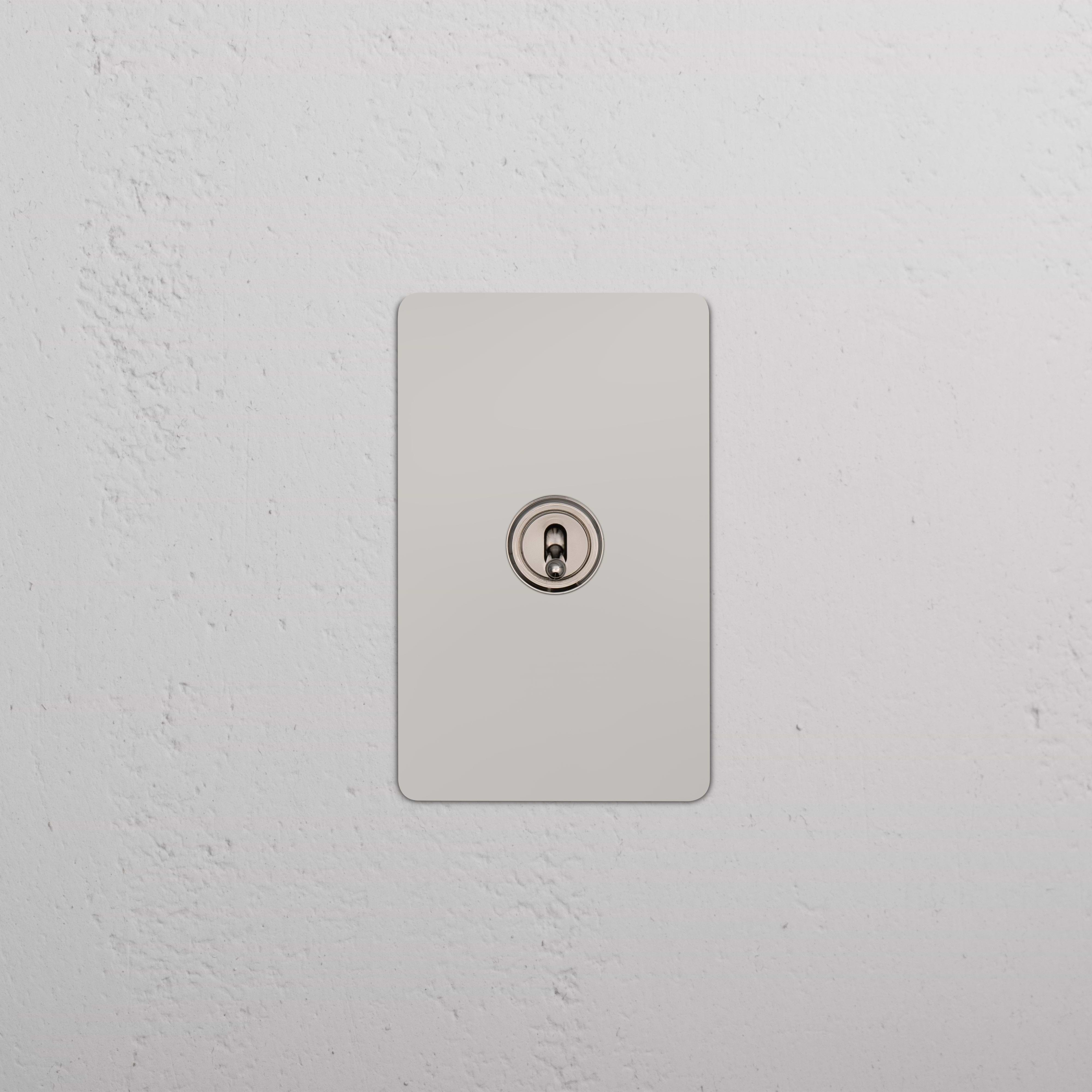 Kew 1G Dimming Retractive Toggle Switch in polished nickel, single rectangular switch plate on wall.