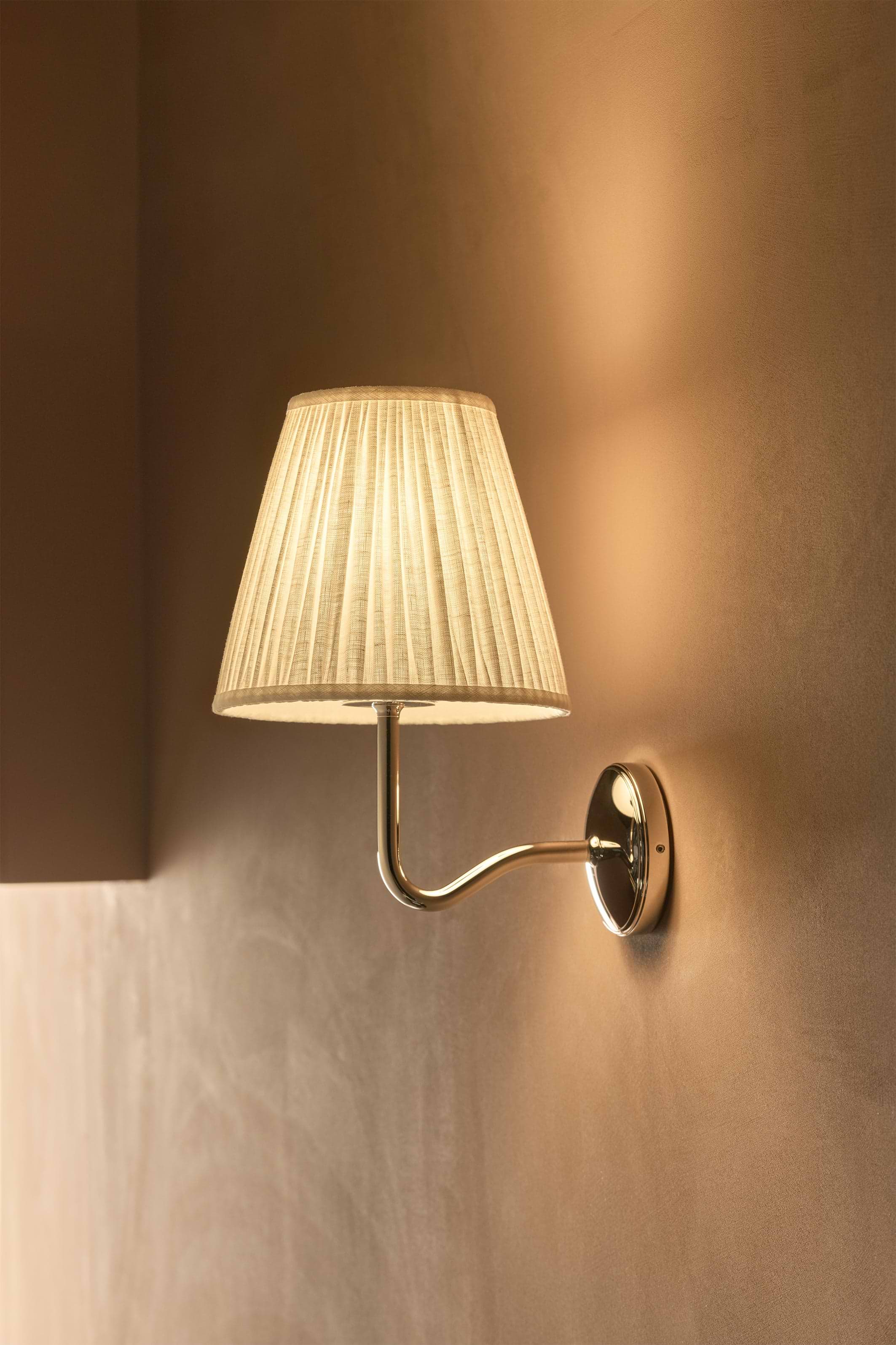 Large Malvern Wall Light in Alabaster White with pleated shade and polished nickel finish mounted on wall.