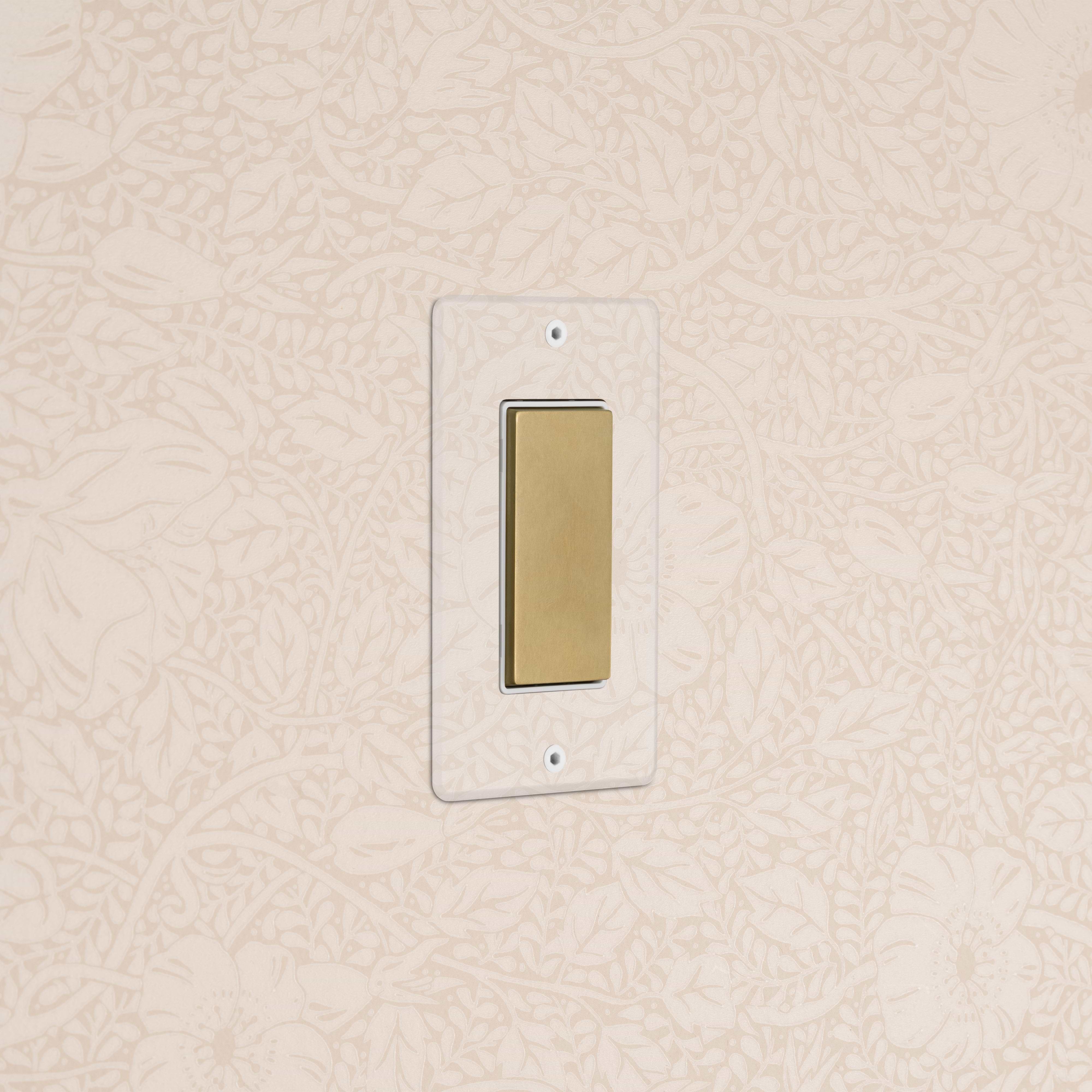Kew 1G Center Retractive Rocker Switch in clear antique brass with white insert, wall-mounted.