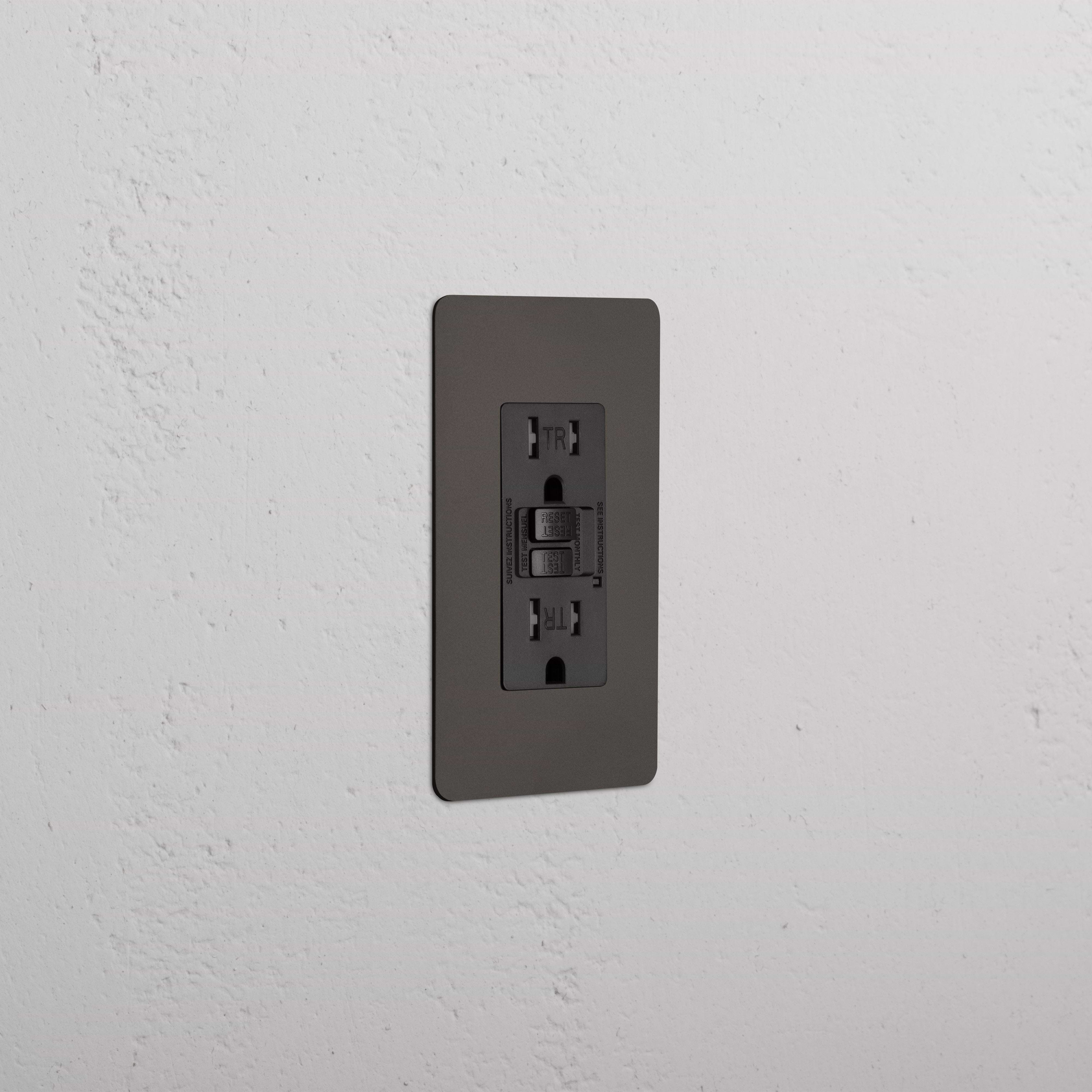 Kew 1G 15A GFCI Outlet in Bronze Black, with two sockets and a central test/reset button.