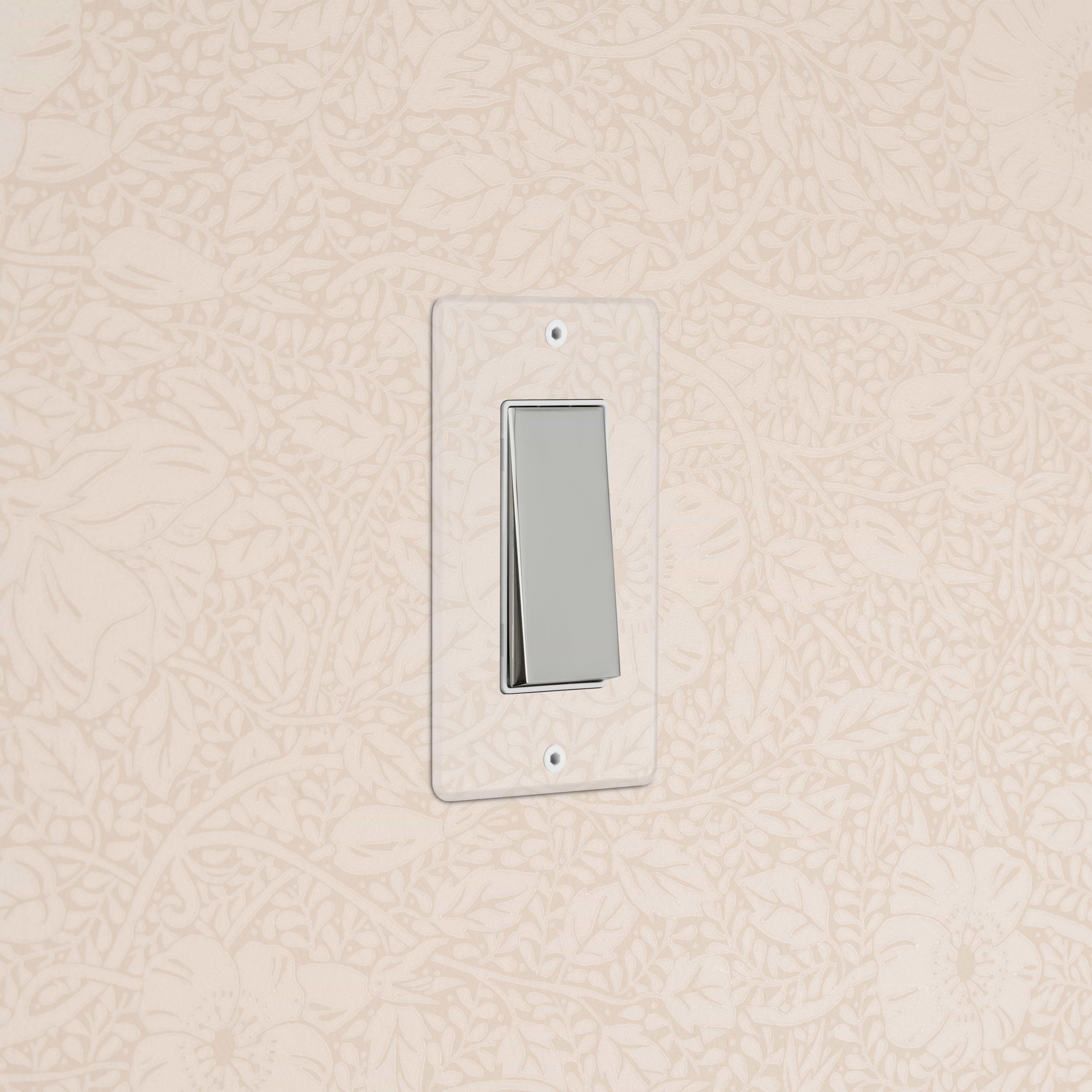 Kew 1G Dimming Retractive Rocker Switch in clear polished nickel with white trim, mounted on a wall.