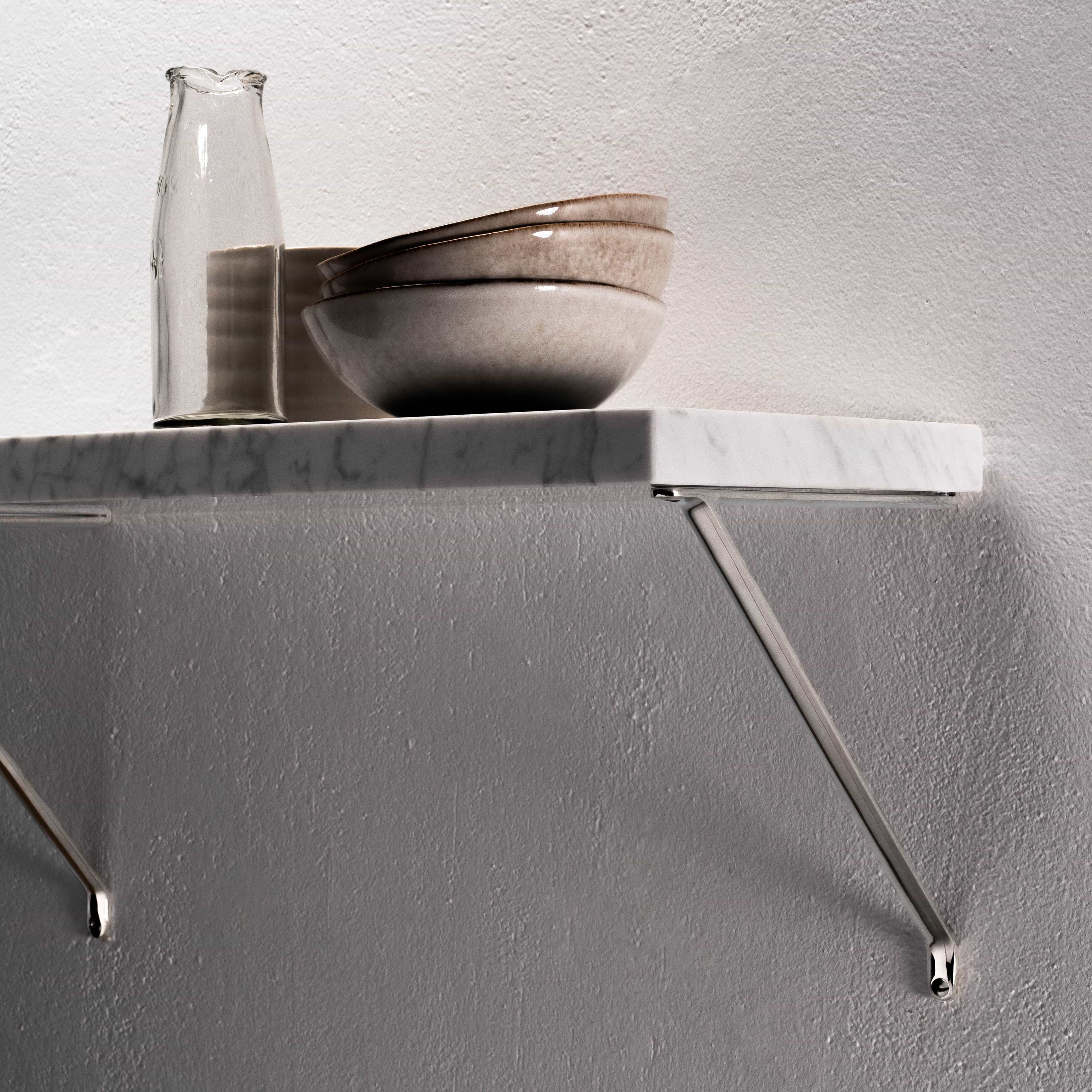 Medium Brixton Shelf Bracket in polished nickel supporting a white marble wall shelf against a light background.