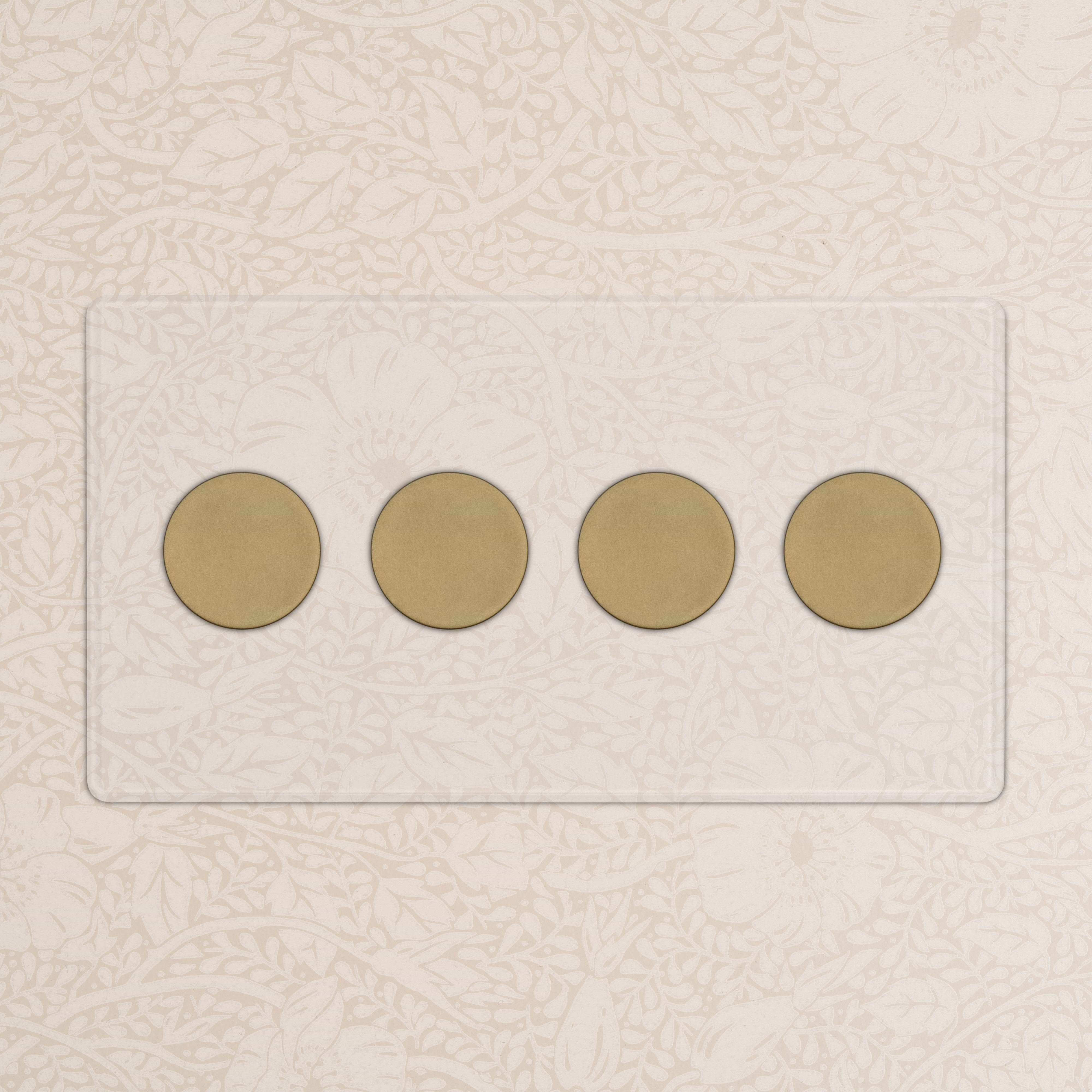 Kew 4G Dimmer Switch in clear antique brass with four round knobs on a glass panel, mounted on a patterned wall.