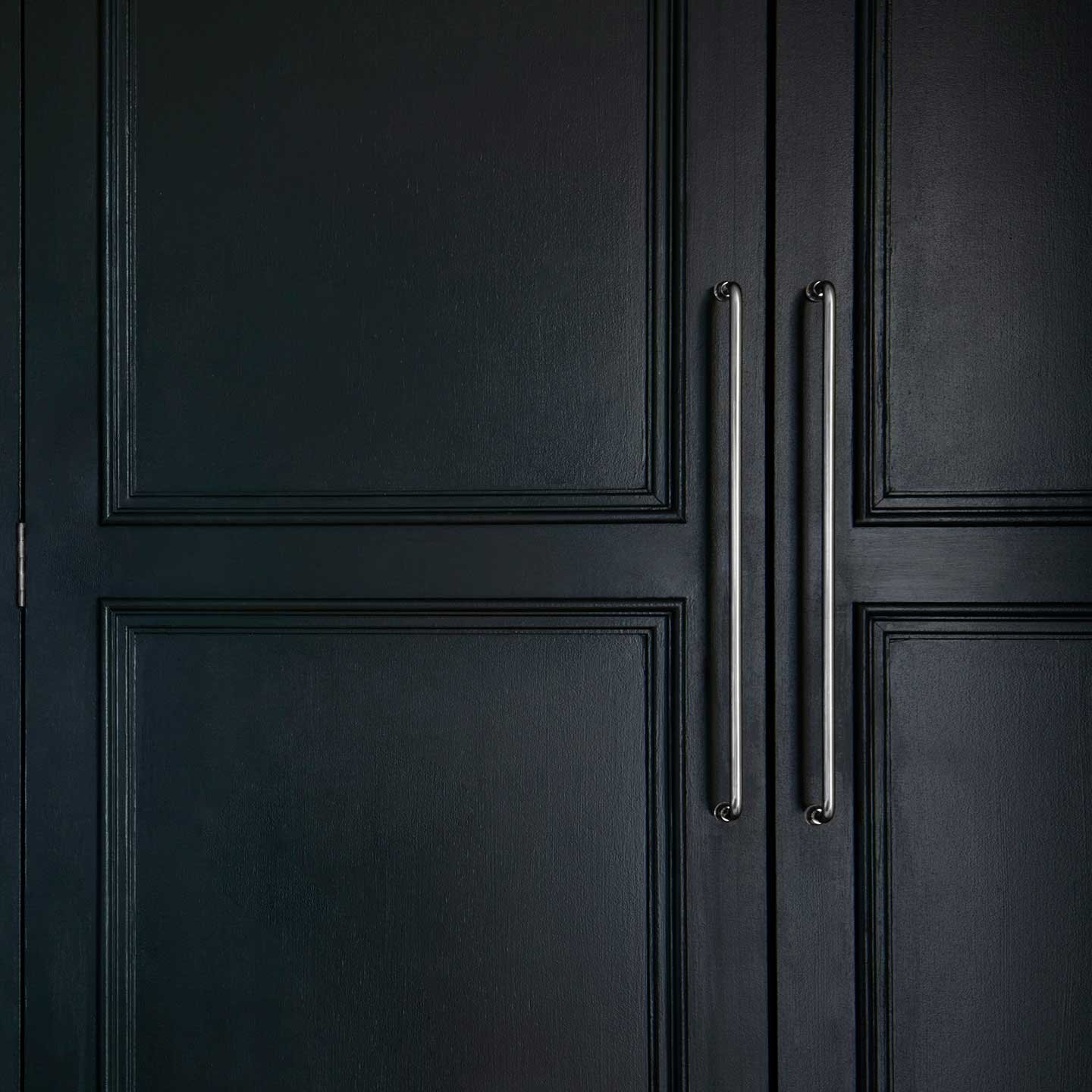 Sycamore Furniture Handle Large in polished nickel finish, mounted vertically on a cabinet door.