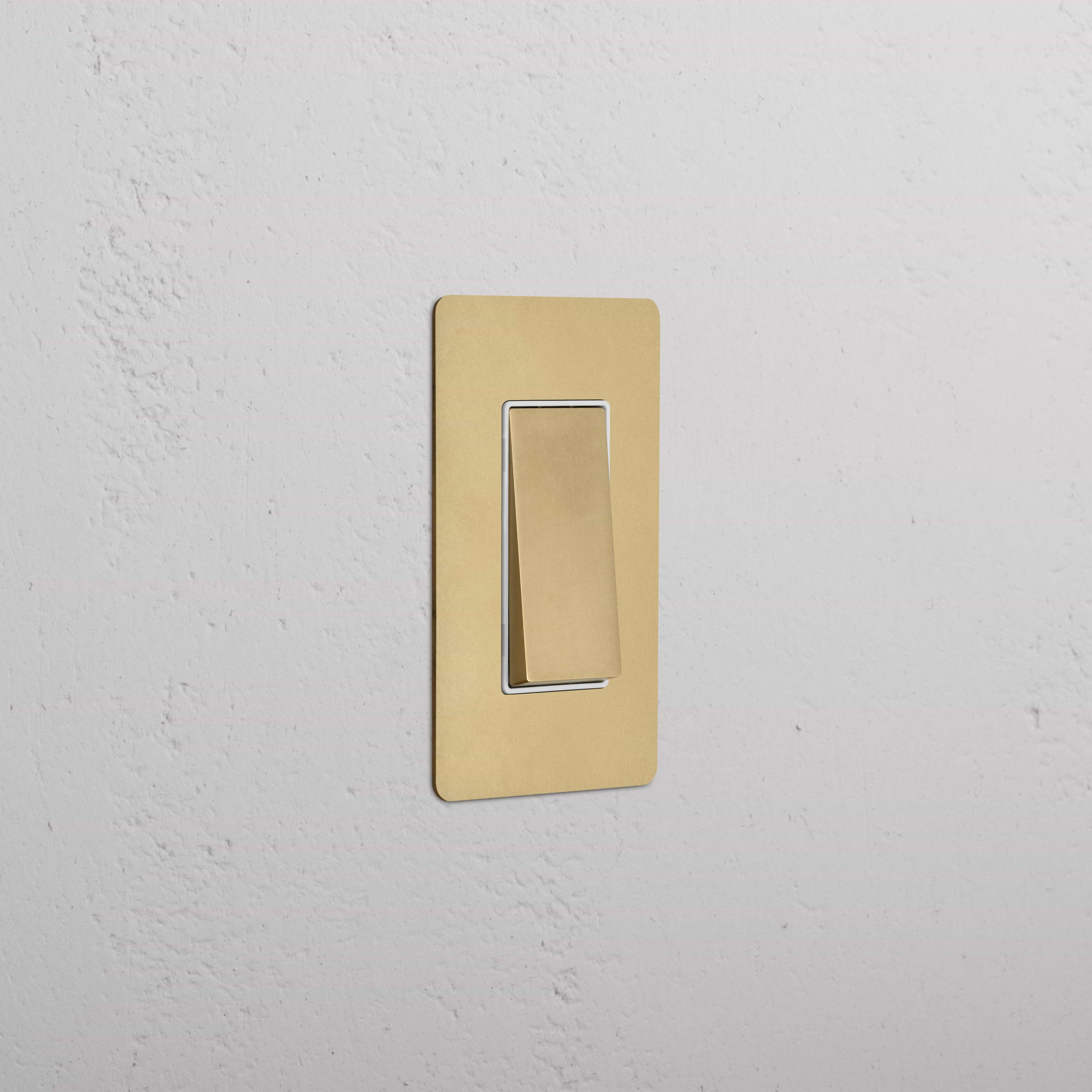 Kew 1G Double Pole Rocker Switch in antique brass white finish, shown in the off position on a wall.