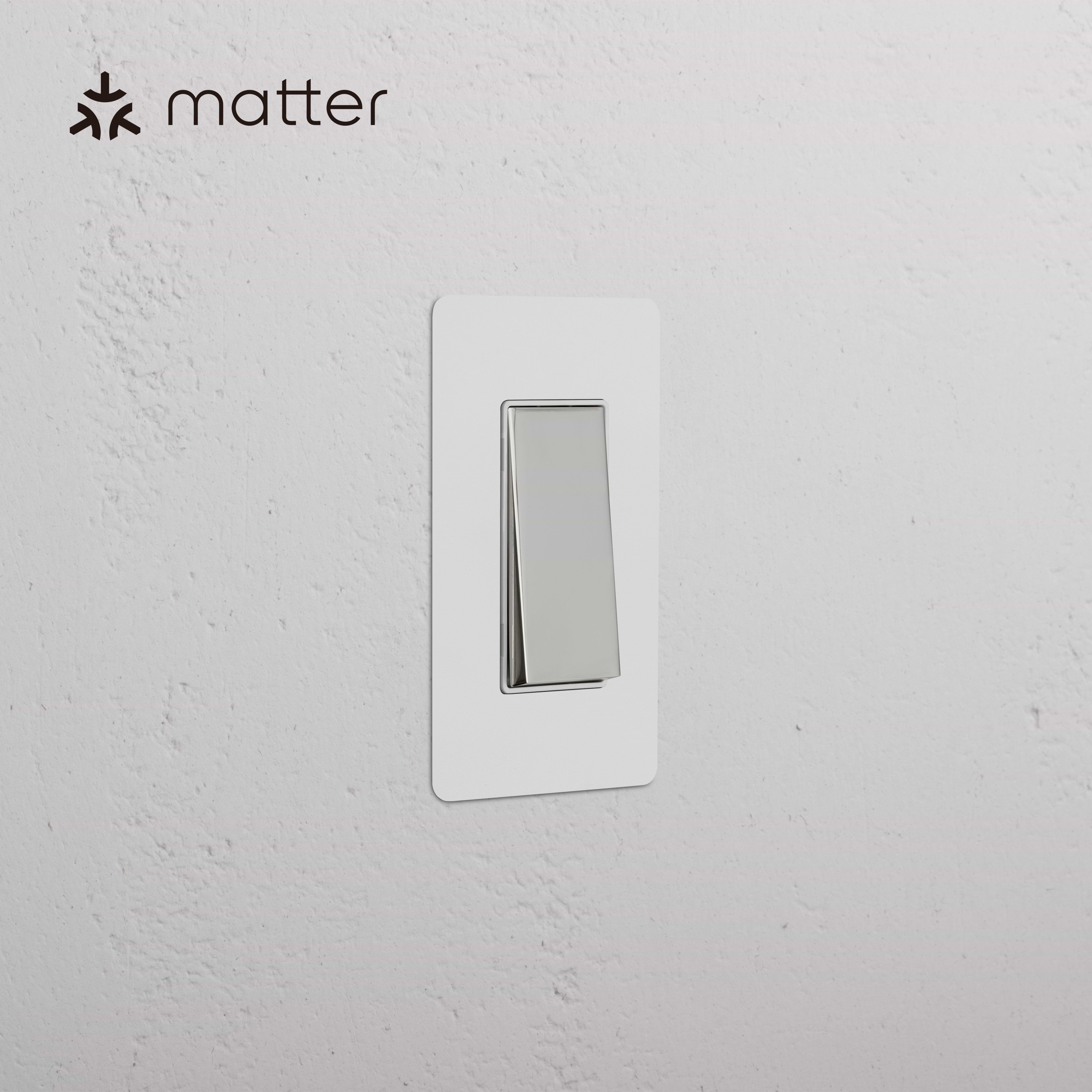 Kew 1G Smart Retractive Rocker Switch in paintable polished nickel white, shown mounted on a wall.