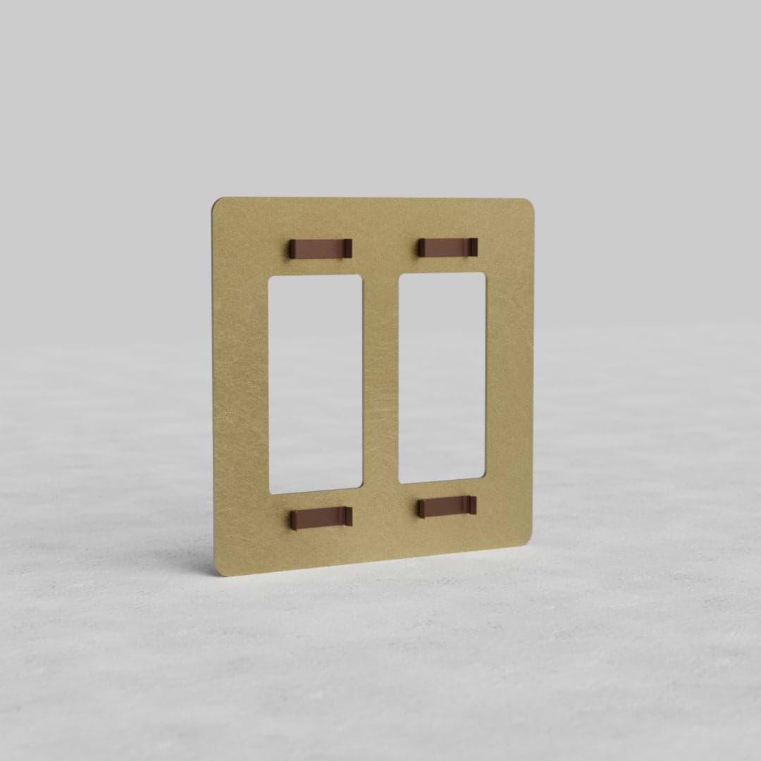 2G Outlet Plate Kew US in antique brass finish, rectangular with two outlet cutouts, on a light surface.