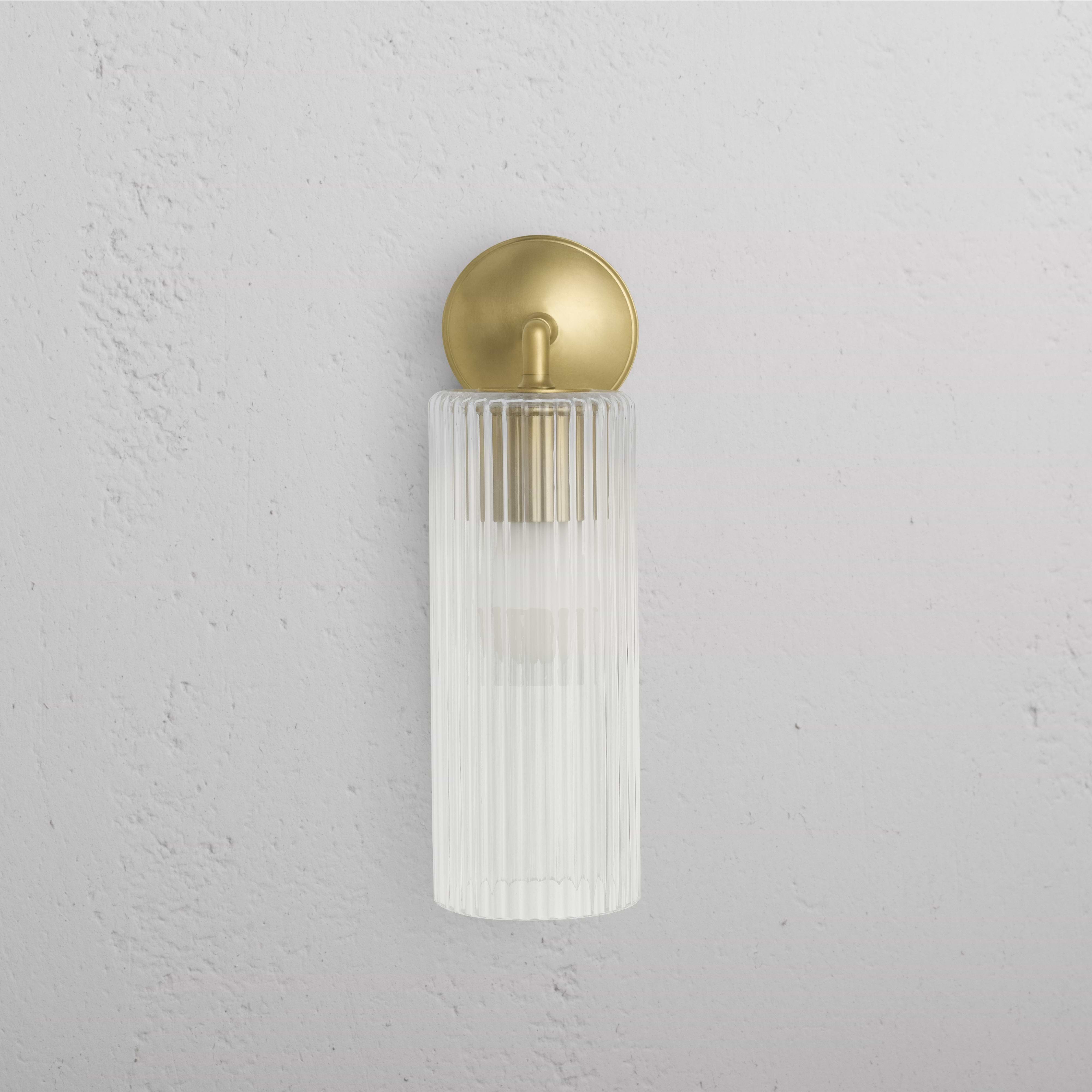 Large Claremont Wall Light with fluted glass shade and antique brass backplate mounted on a white wall.