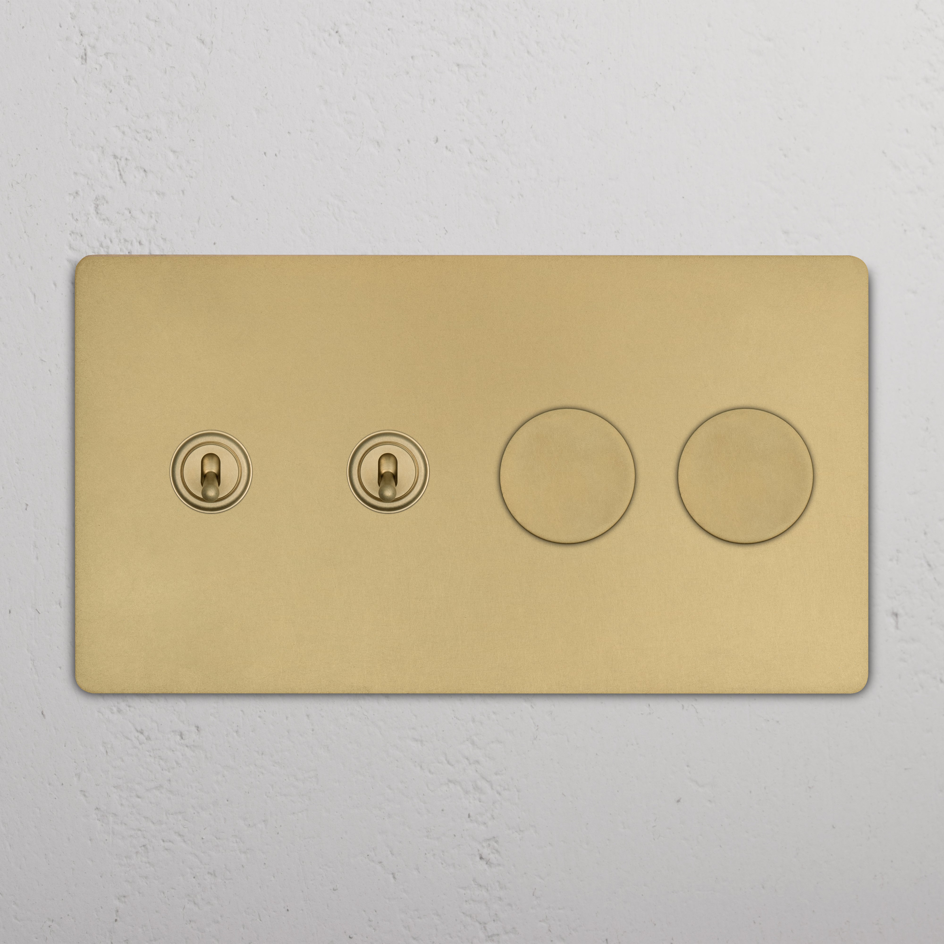 Grove 4G switch in antique brass with two toggle switches and two dimmer knobs, mounted on a wall.