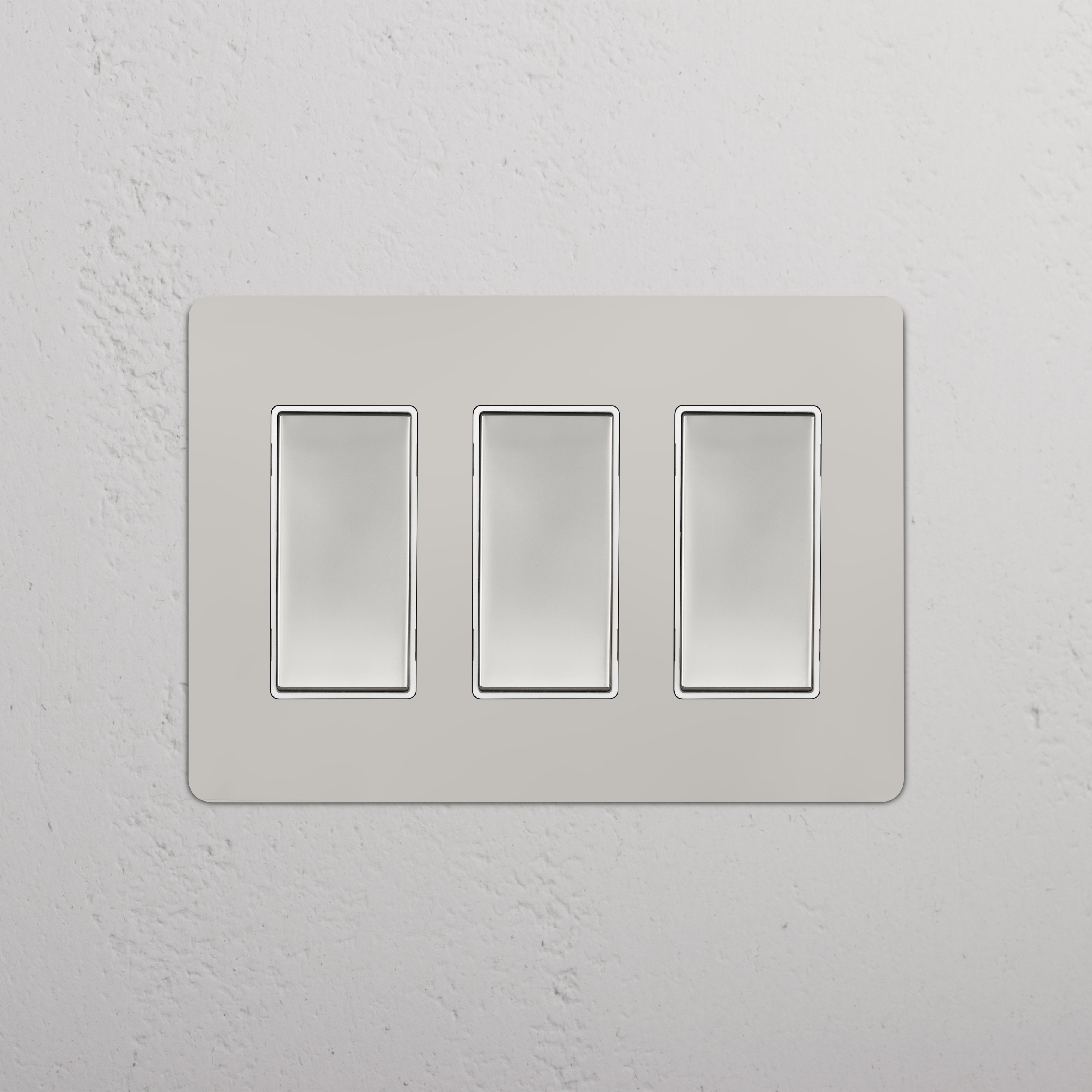 Kew 3G Rocker Switch in Polished Nickel White with three rectangular switches on a white wall plate.