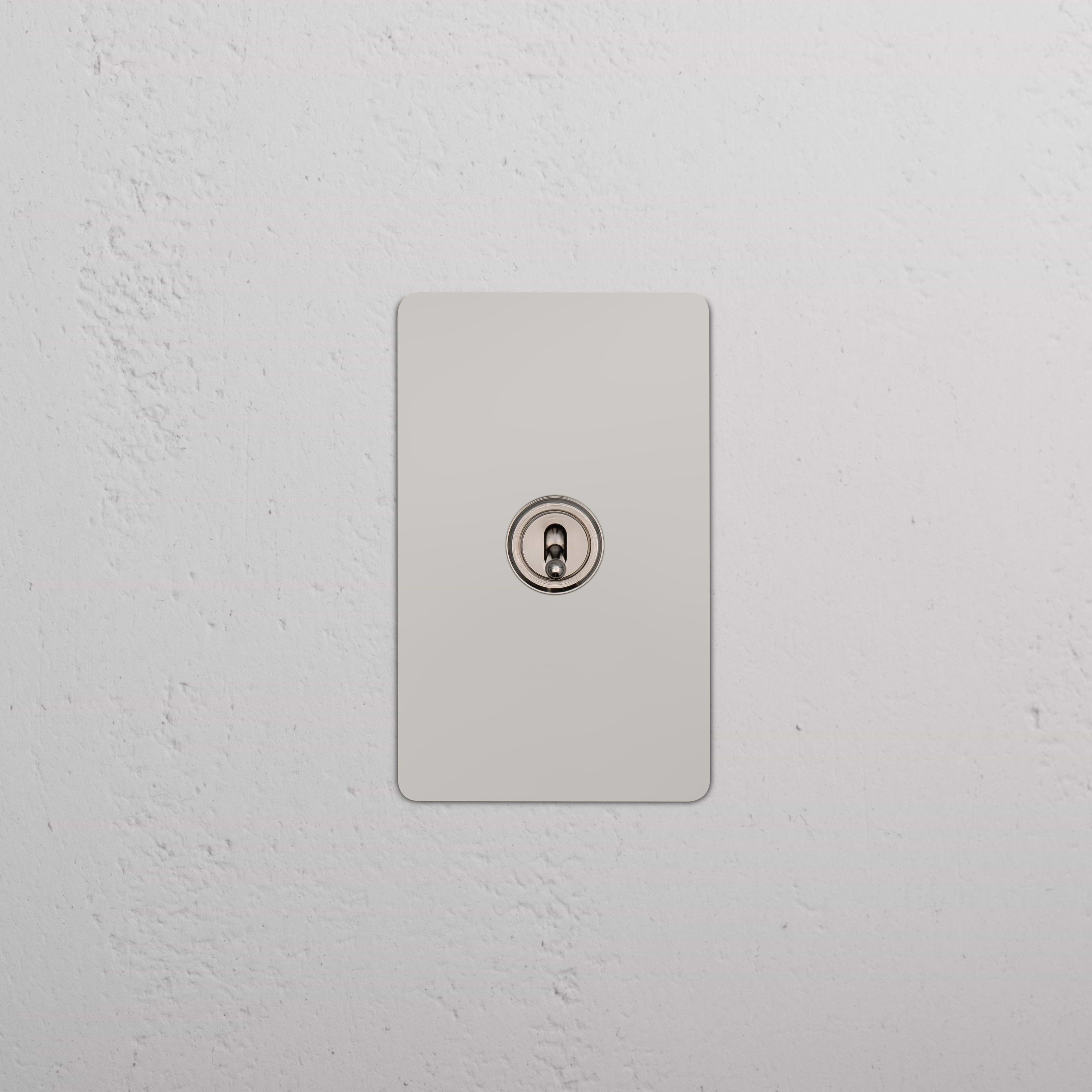 Kew 1G Smart Retractive Toggle Switch in polished nickel, mounted on a white textured wall.