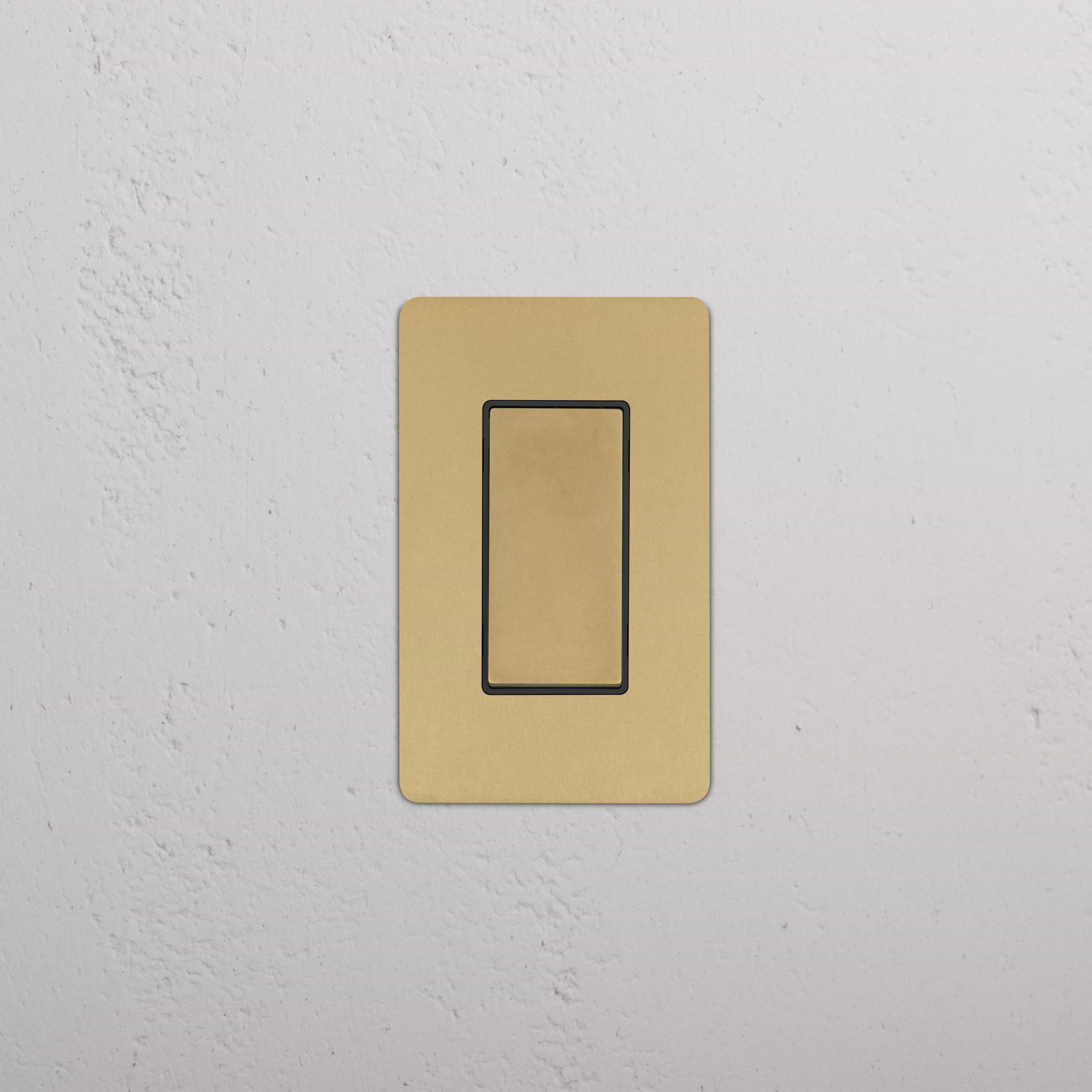 Kew 1G Double Pole Rocker Switch in Antique Brass Black finish, mounted on a white textured wall.