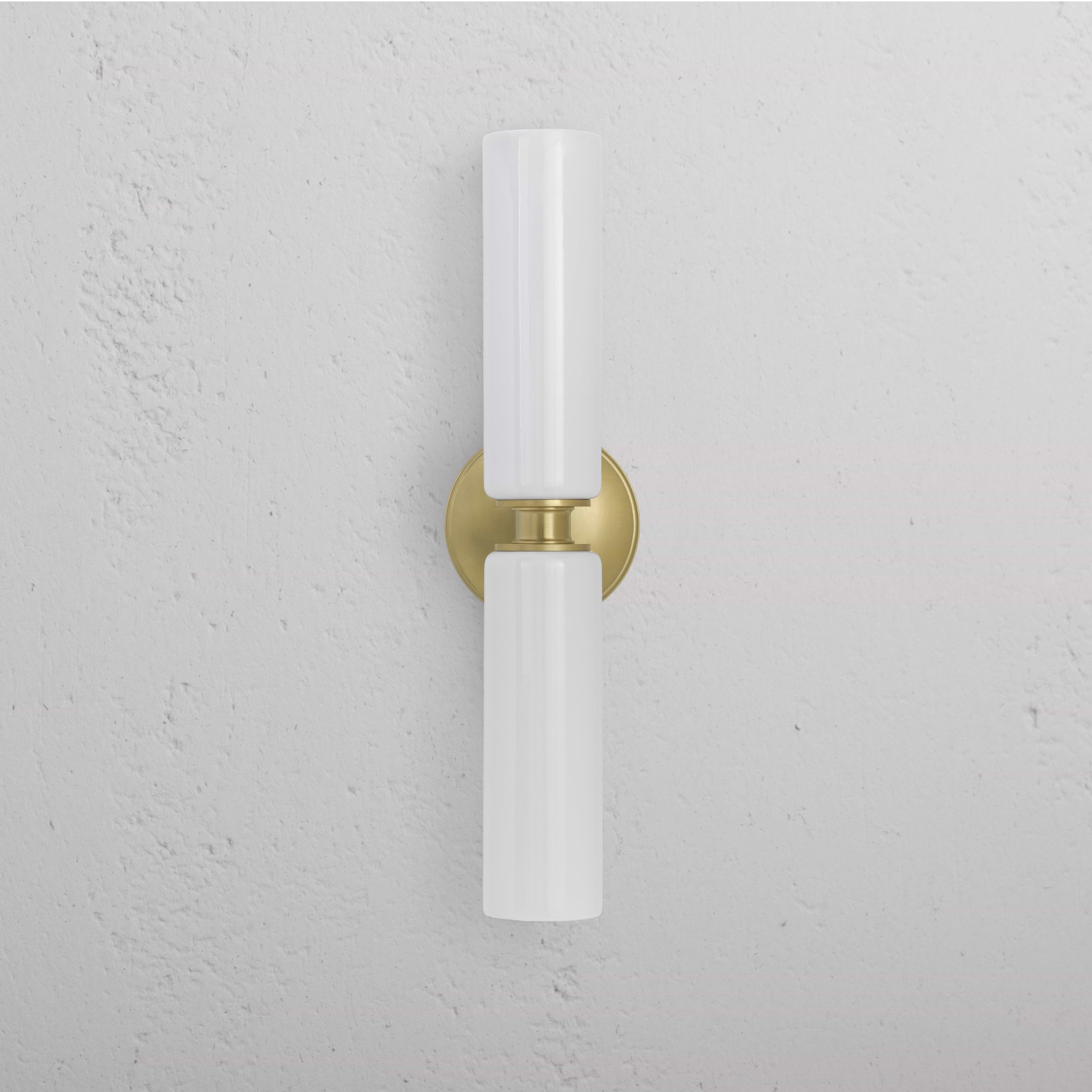 Claremont Medium Wall Light in fine porcelain with two vertical white shades on an antique brass base.