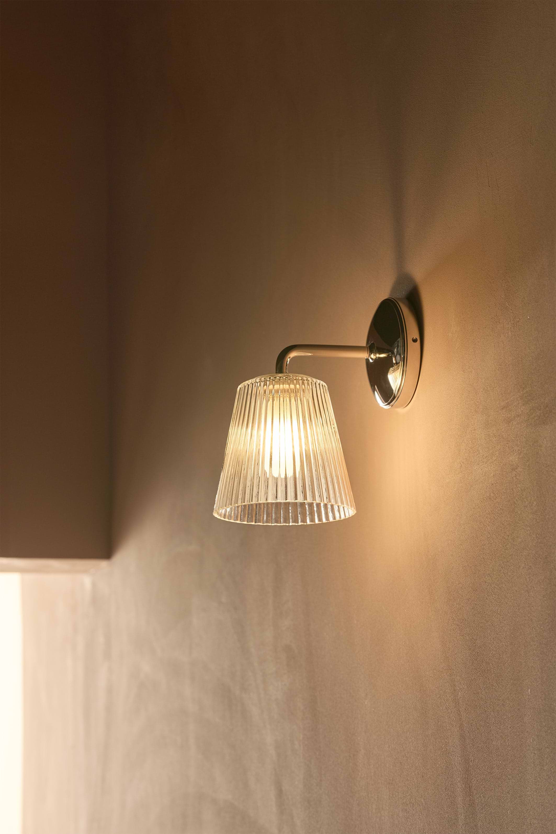 Richmond Medium Wall Light with fluted clear glass shade and polished nickel finish mounted on a wall.