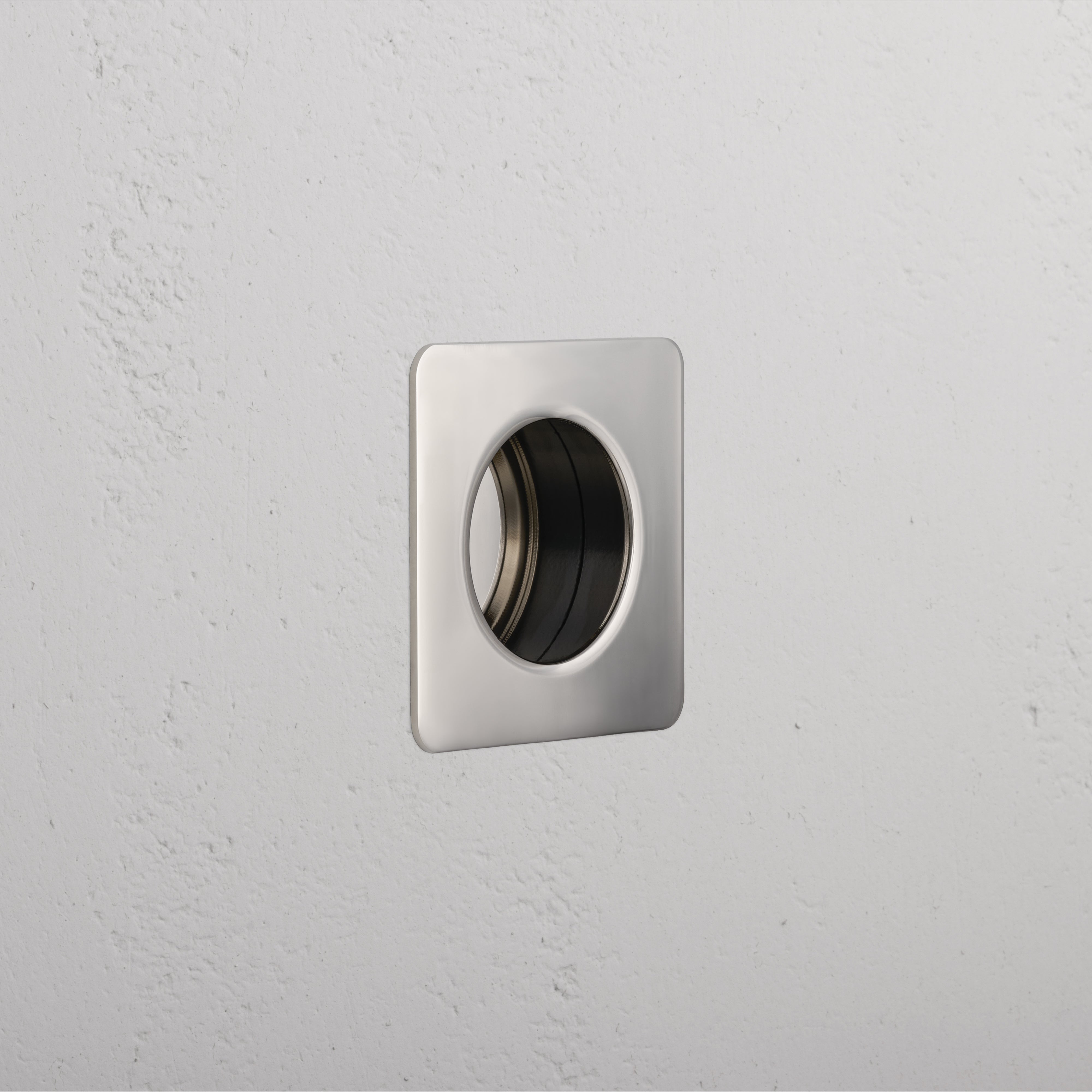 Regent Recessed Small Pull in Polished Nickel, square design with central round recess, mounted on white wall.
