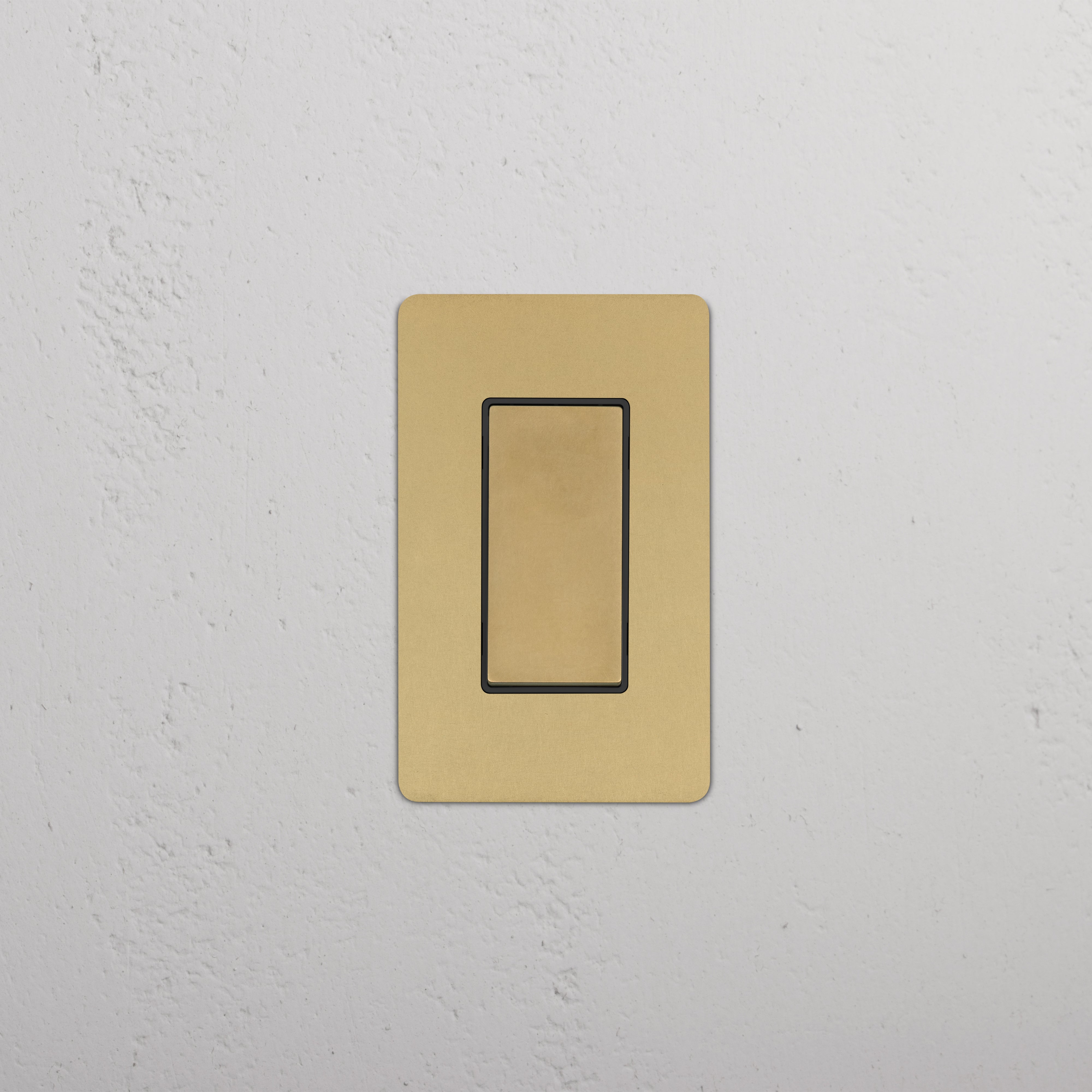 Kew 1G Rocker Switch in antique brass black finish, single gang, shown installed on a white wall.