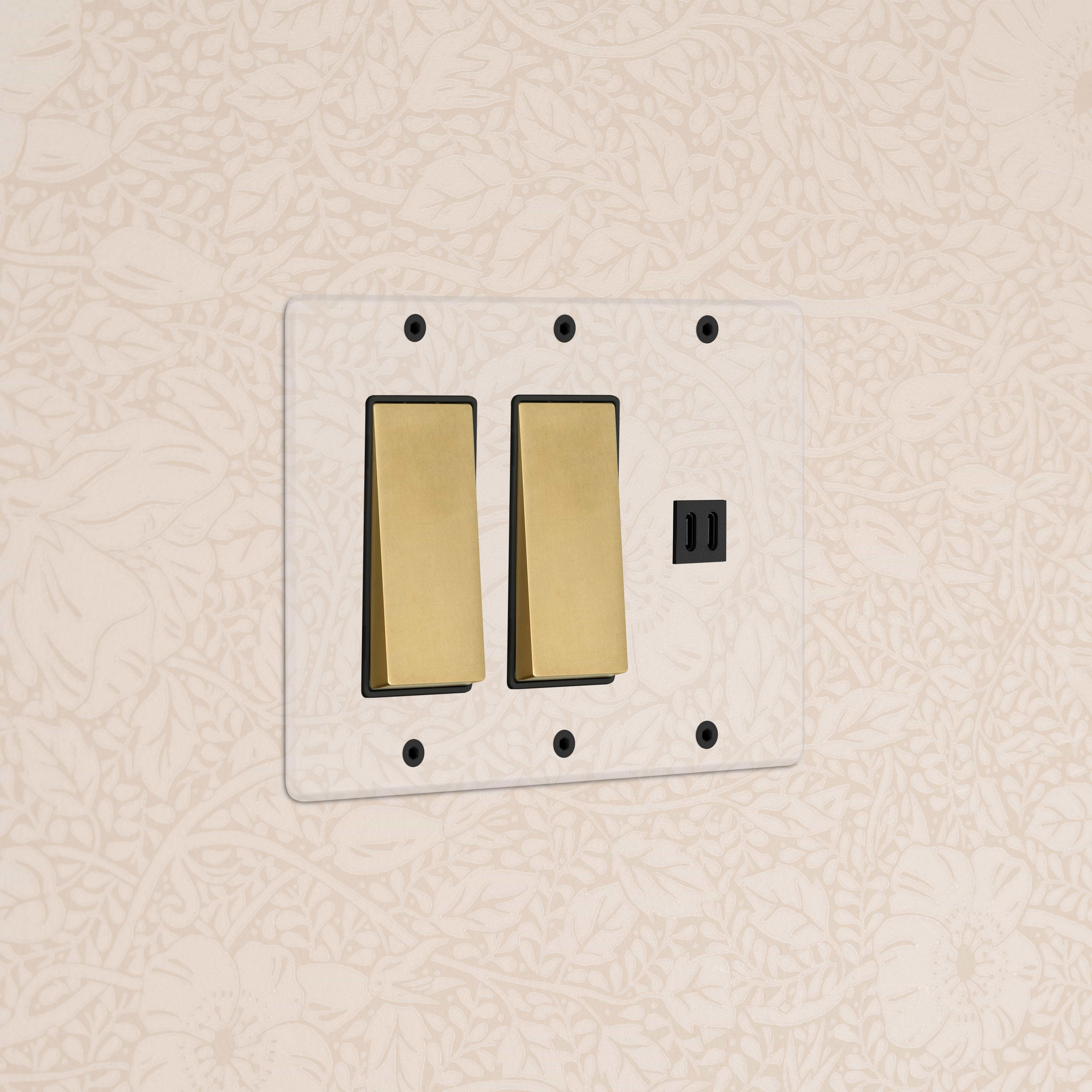 Clear Antique Brass Black 3-gang double rocker light switch with fast charge USB, by Kew, on wall plate.