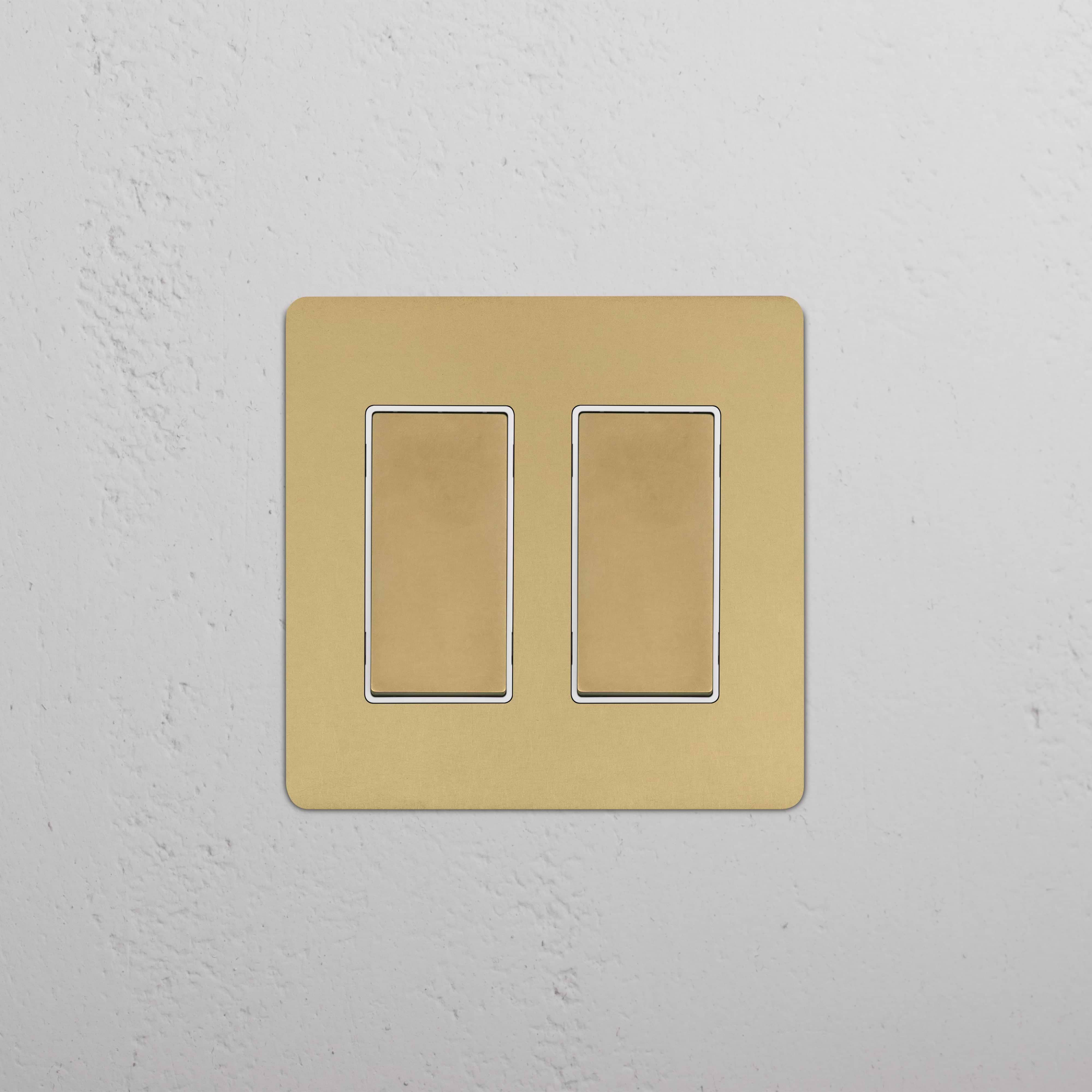 Kew 2G Rocker Switch – Antique Brass White with double rocker switches on a rectangular brass plate.