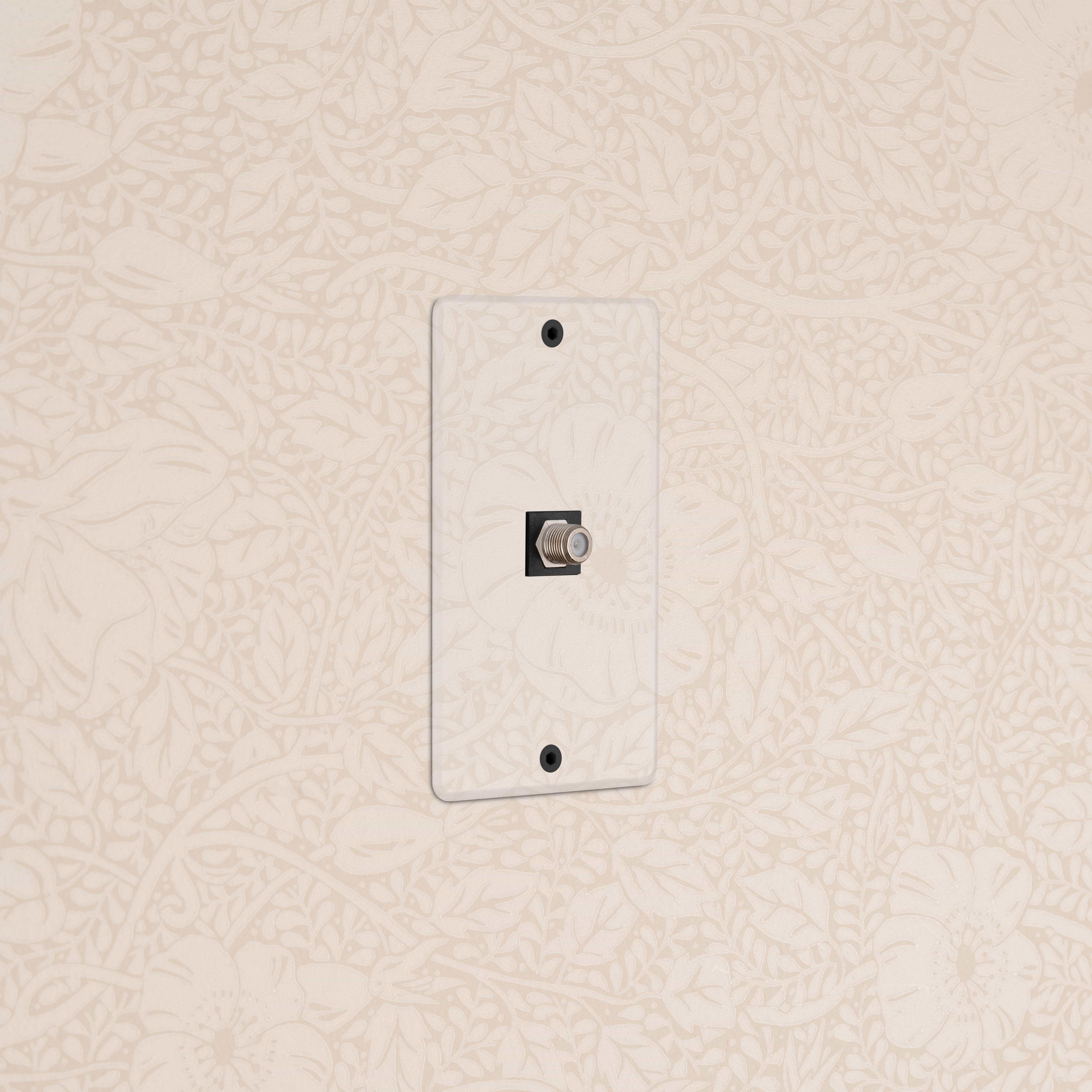 Kew 1G Satellite Keystone in clear black finish, designed for wall mounting on a floral wallpapered surface.