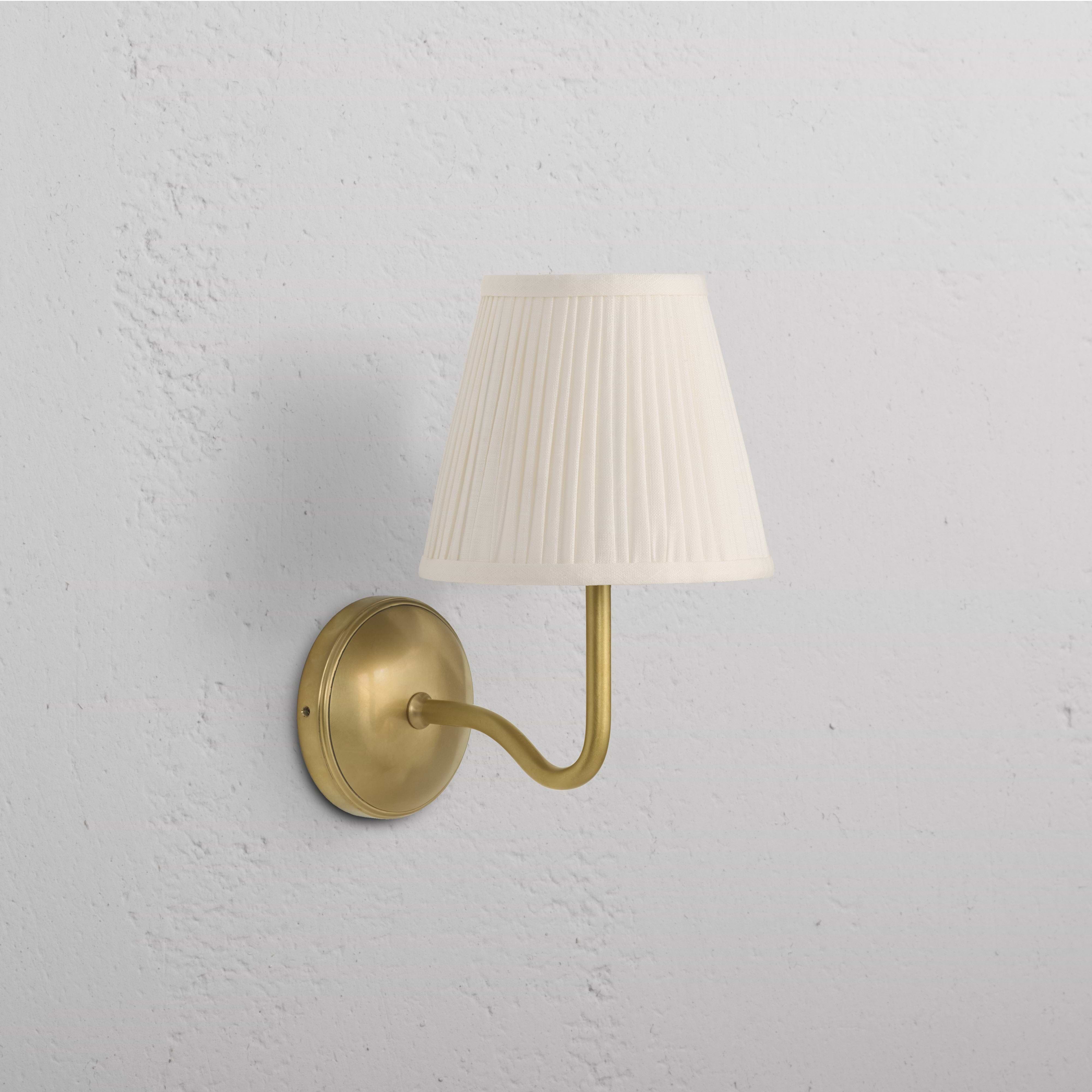 Malvern Medium Wall Light in Alabaster White with antique brass base and arm, white pleated shade.