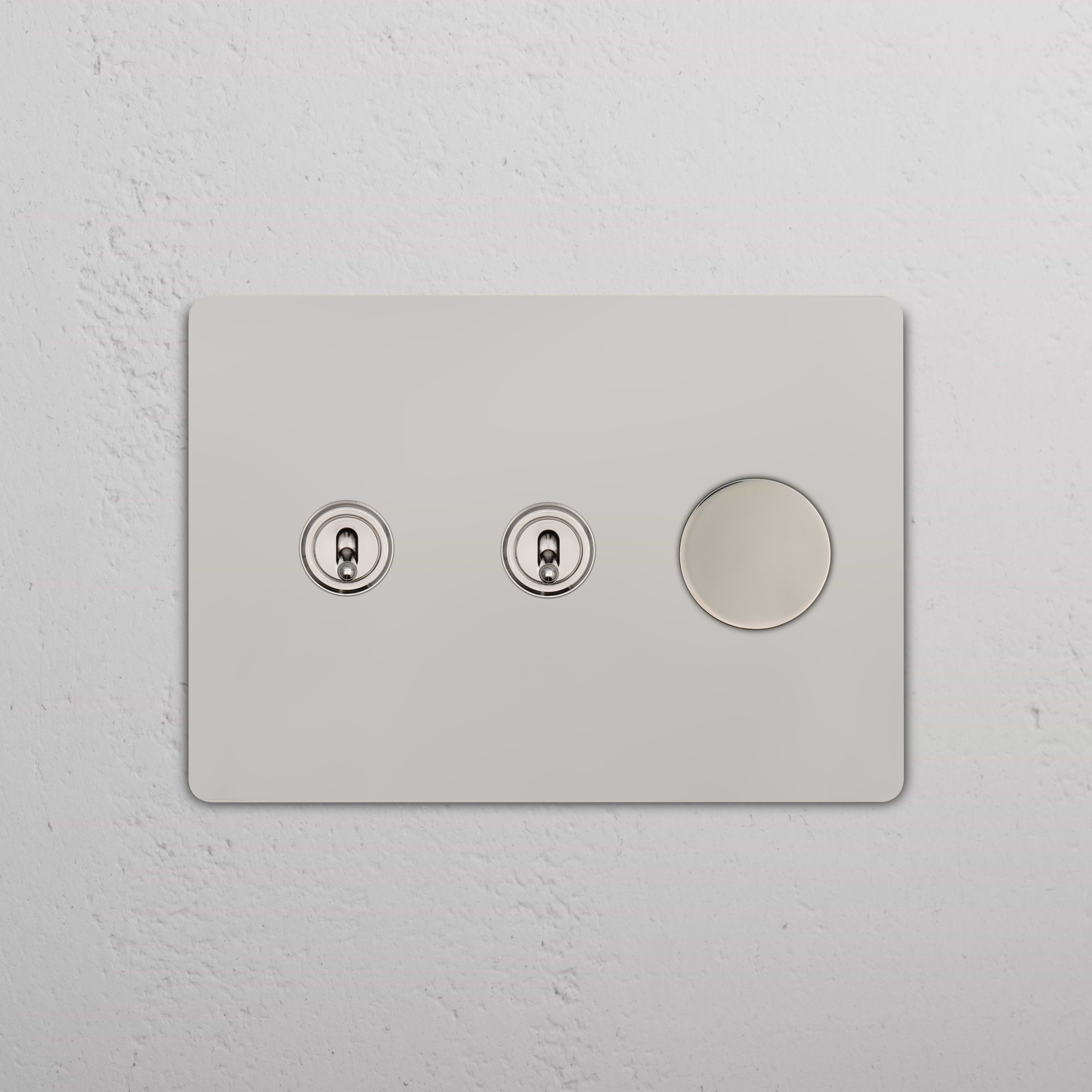 Grove 3G 2x Toggle & Dimmer Switch in polished nickel with two toggles and one dimmer on a wall.