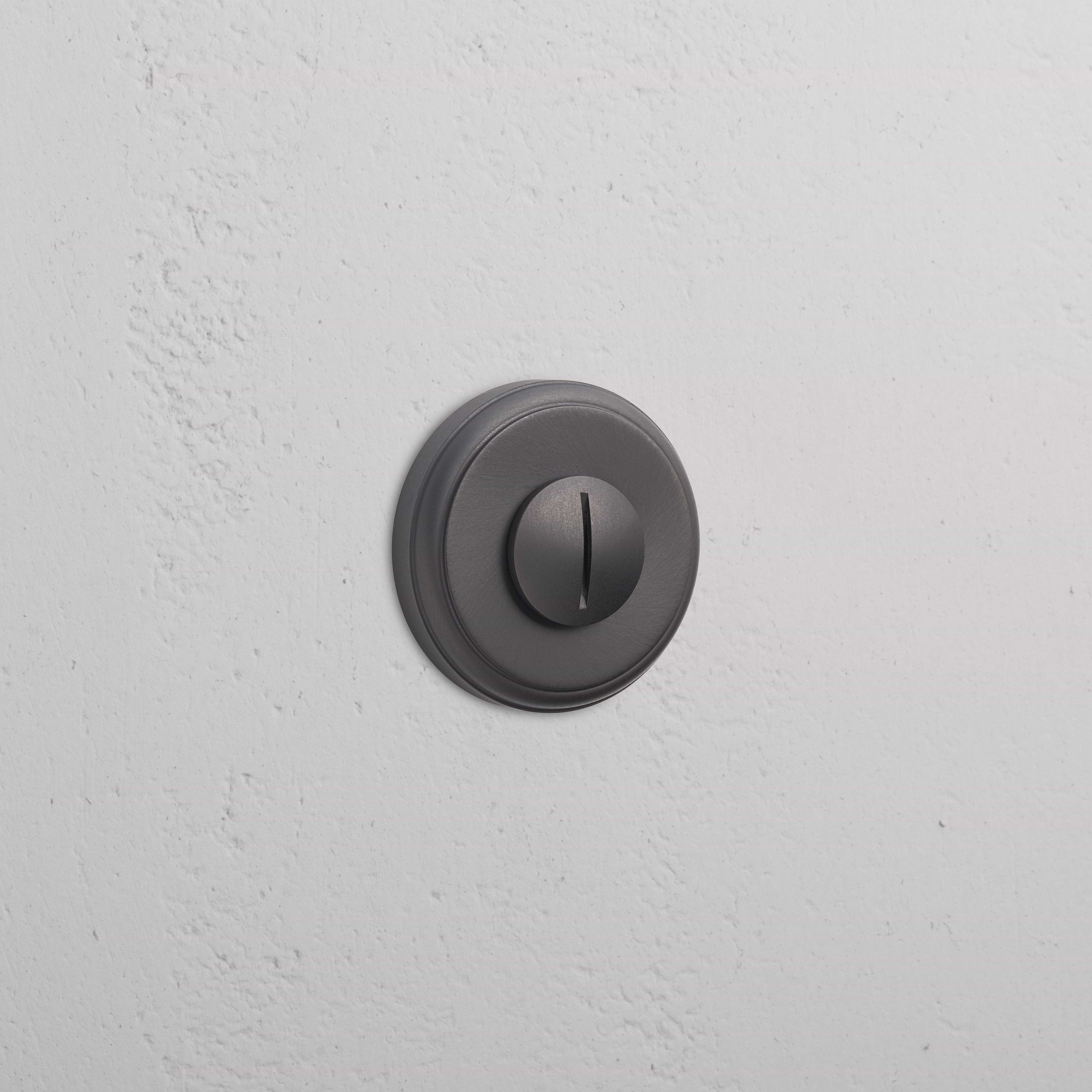 Bronze Canning Privacy Deadbolt installed on a white textured wall, featuring a modern round design.