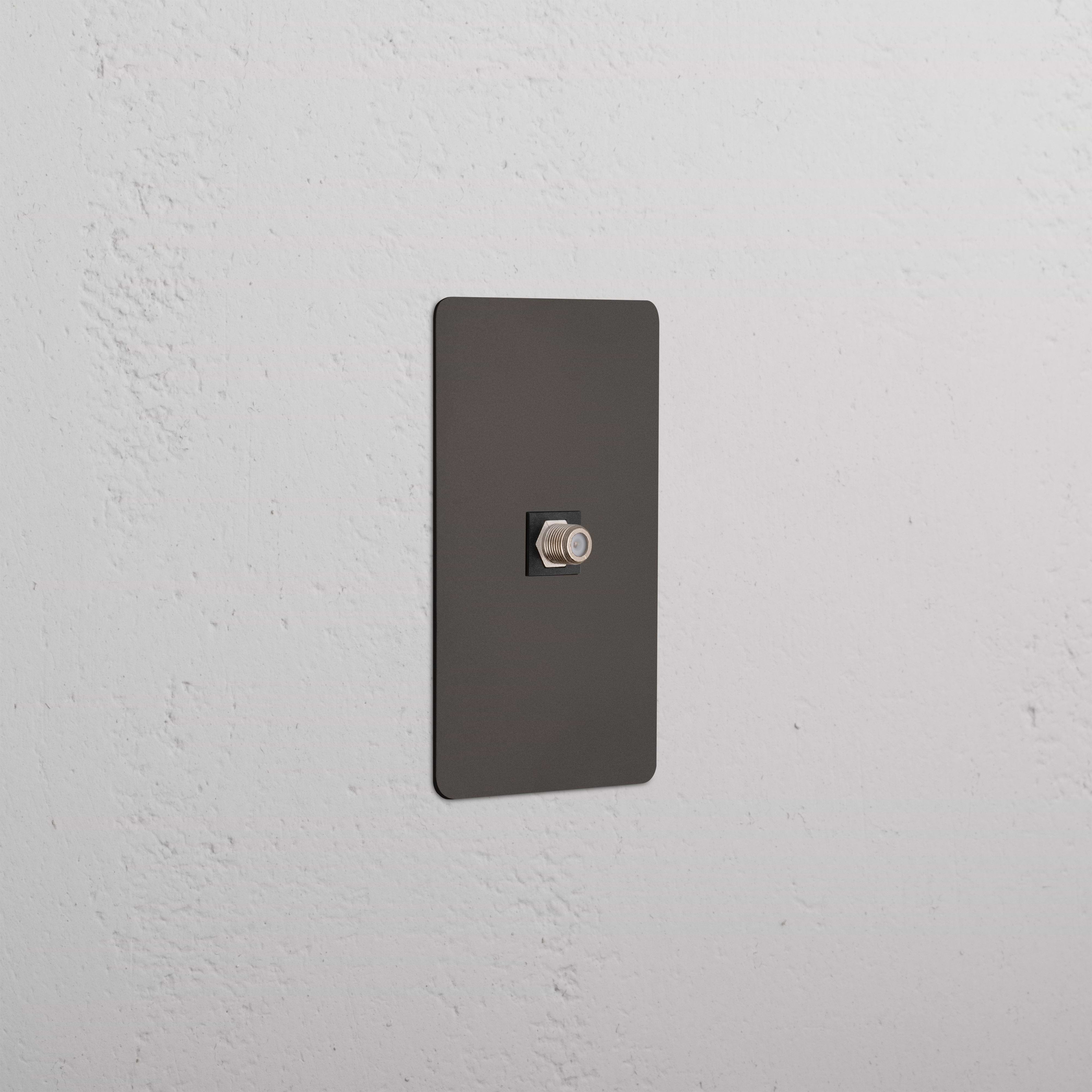 Kew 1G Satellite Keystone in Bronze Black with a central satellite port, shown on a white wall.