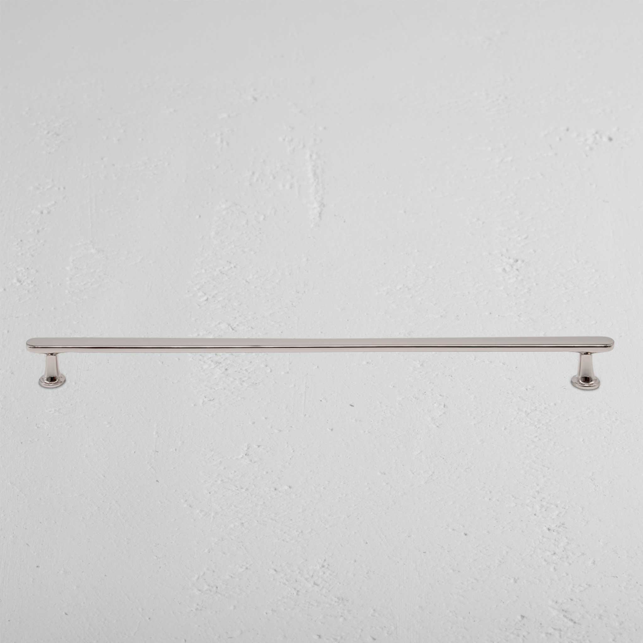 Large Milliner furniture handle in polished nickel finish, mounted horizontally on a white wall.
