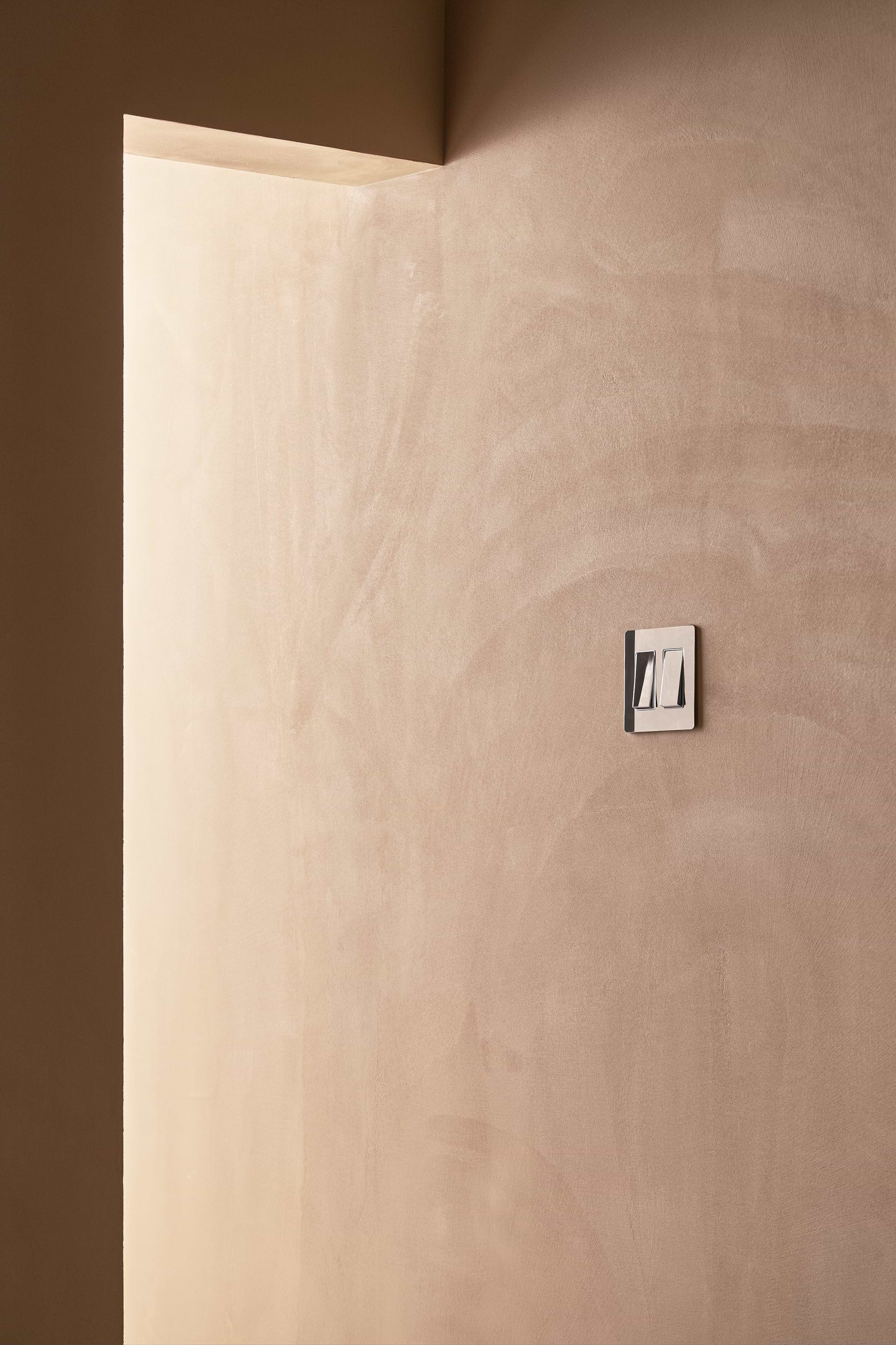 Kew 2G Rocker Switch in Polished Nickel White mounted on a wall, showing two white rocker switches.