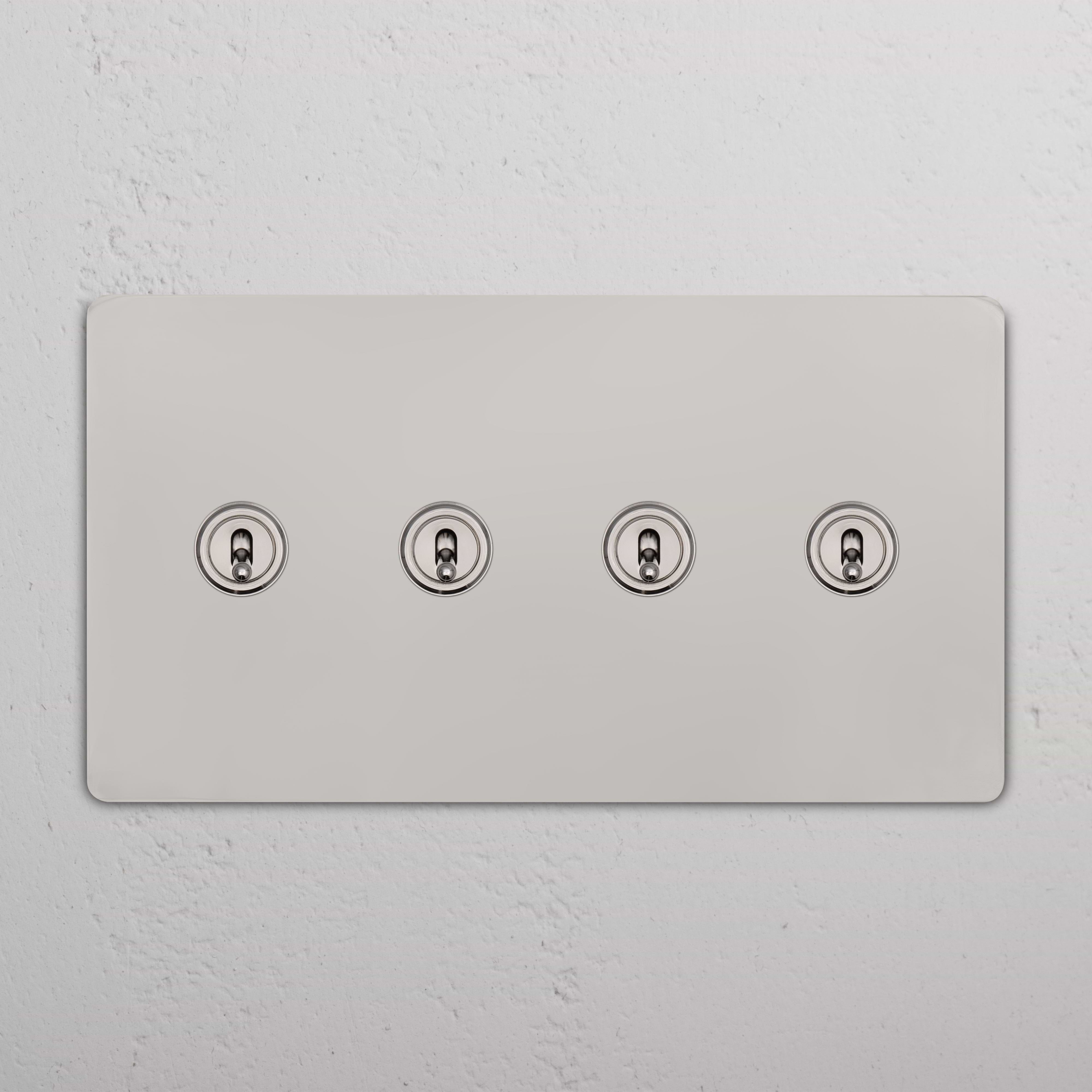 Polished nickel Grove 4G Toggle Switch with four round toggles in a horizontal row on a rectangular plate.