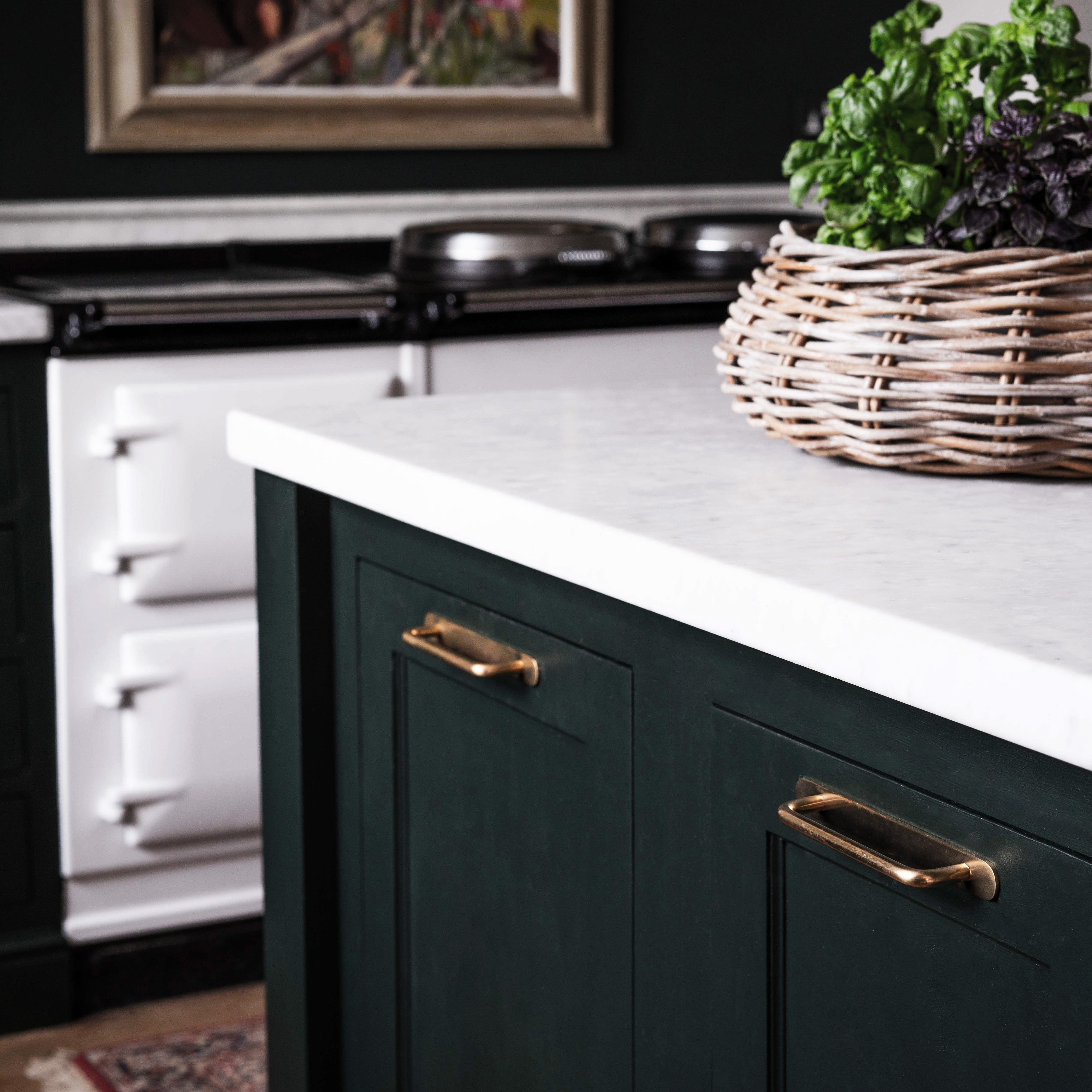 Close-up of a Kilburn Furniture Handle Medium in antique brass fitted on a green cabinet drawer.