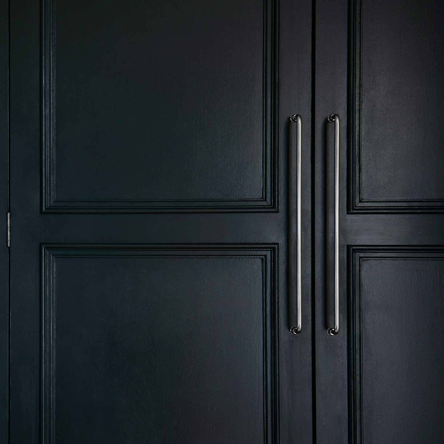 Sycamore Furniture Handle Large in polished nickel finish, mounted vertically on a cabinet door.