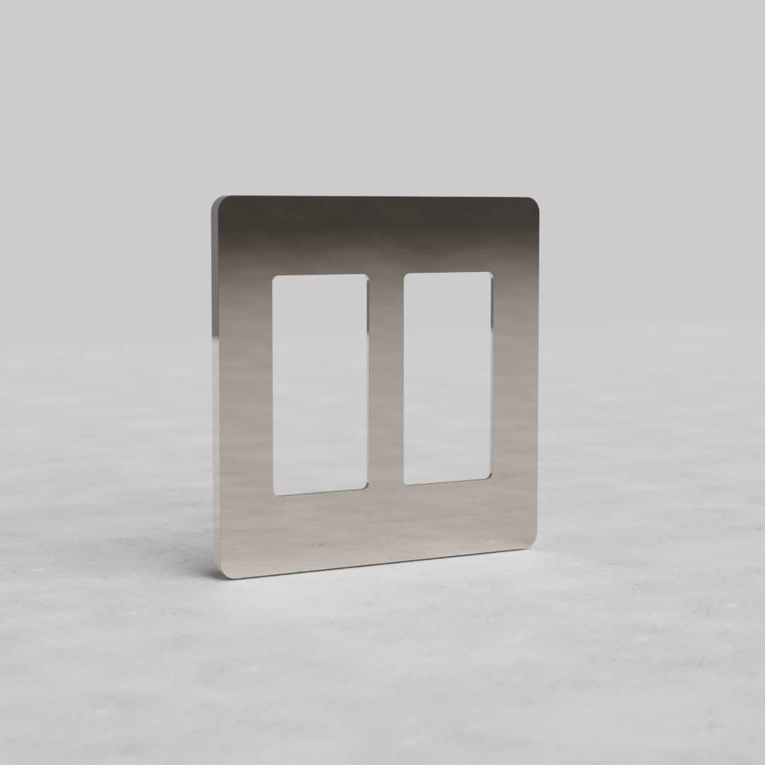 2G outlet plate in polished nickel by Grove US, with two rectangular openings, shown on a light gray surface.