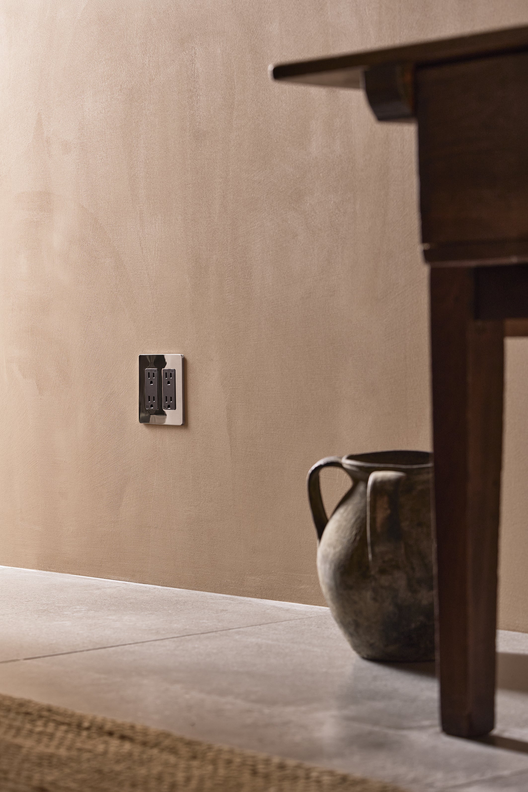 Grove 2G Outlet in polished nickel black finish, double power socket on a beige wall.