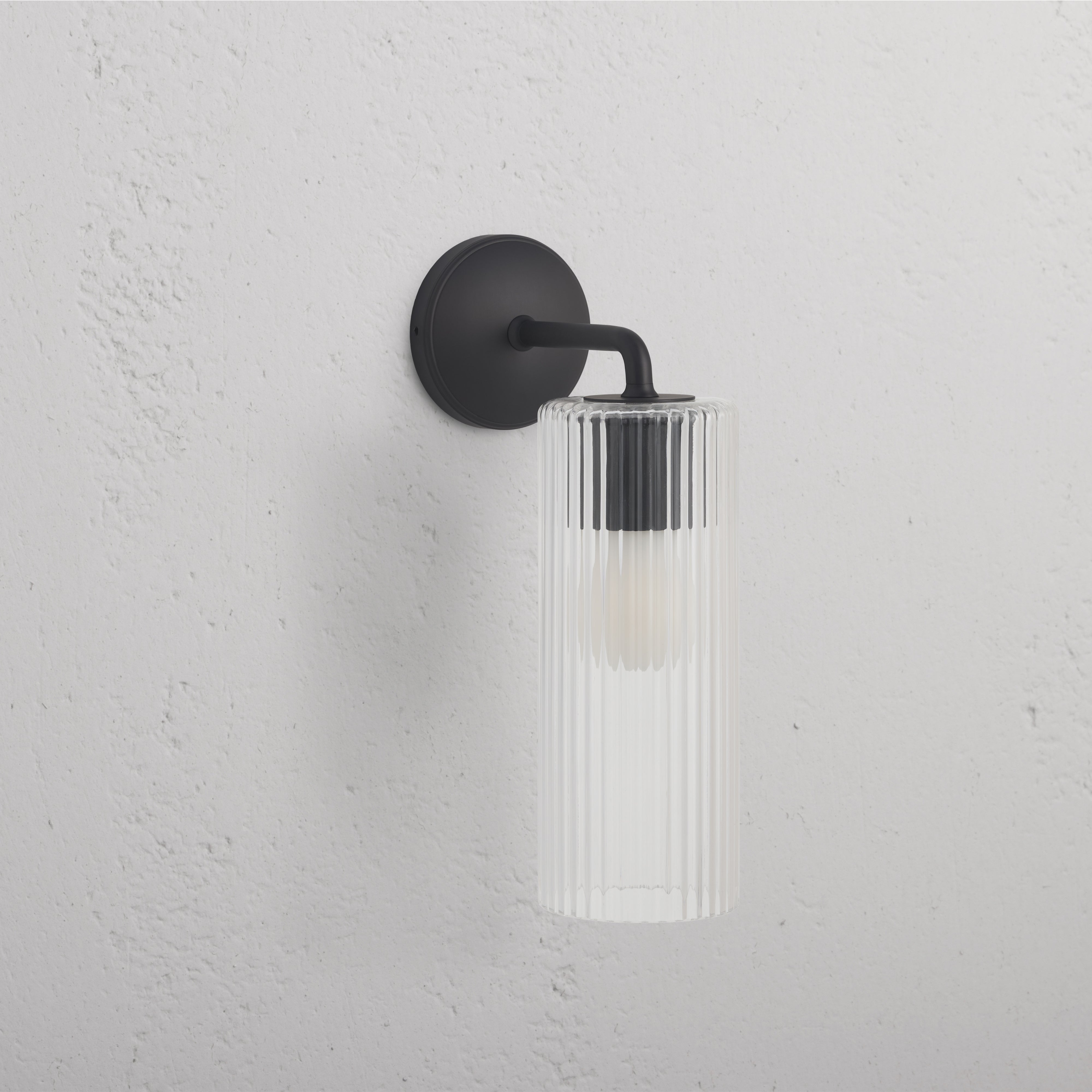 Large Claremont Wall Light Fluted Glass in bronze finish, with vertically fluted glass shade on a wall.