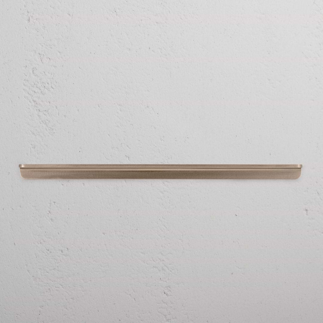 Large antique brass Oxford furniture handle with a classic design, shown against a white textured background.