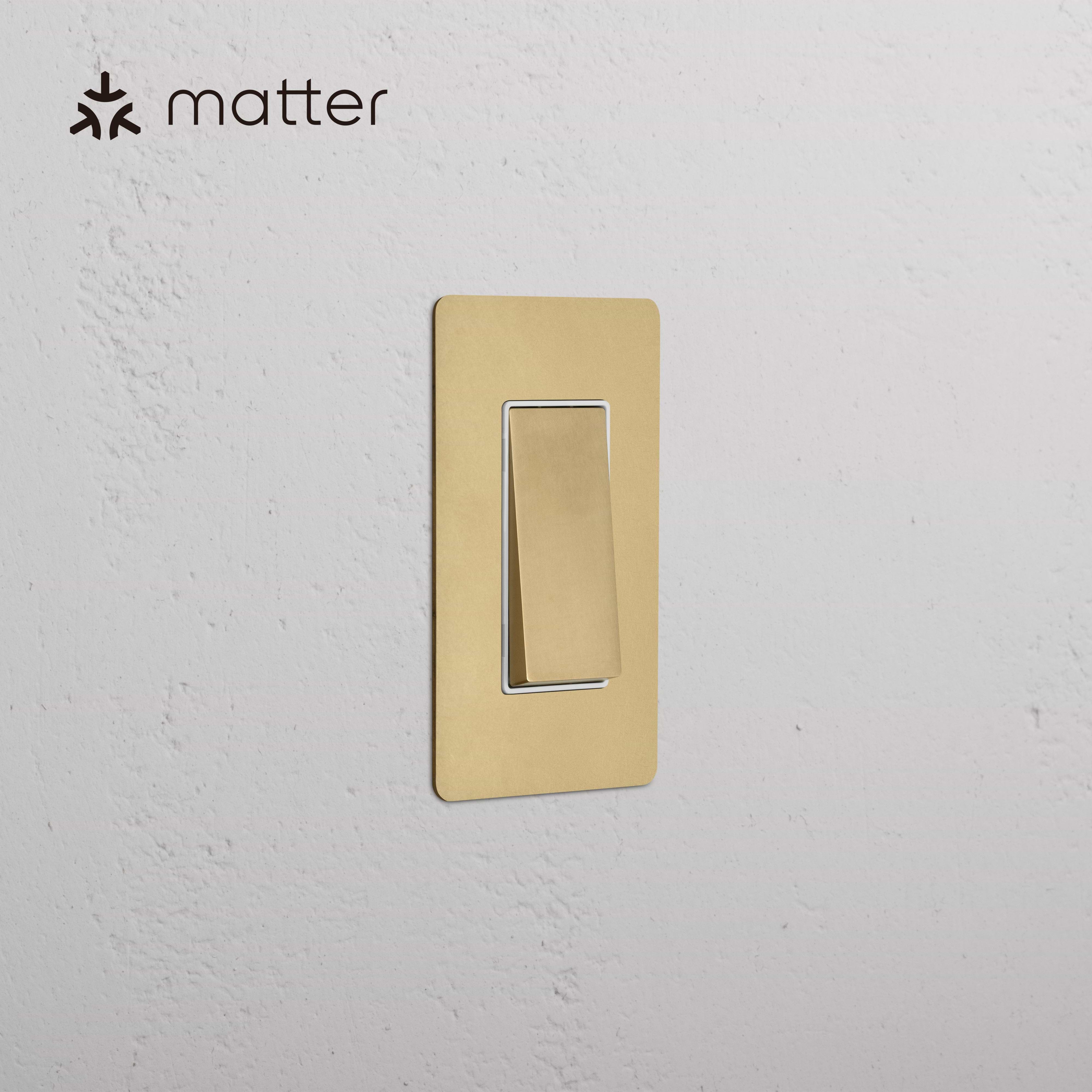 Kew 1G Smart Retractive Rocker Switch in Antique Brass White, mounted on a white wall.