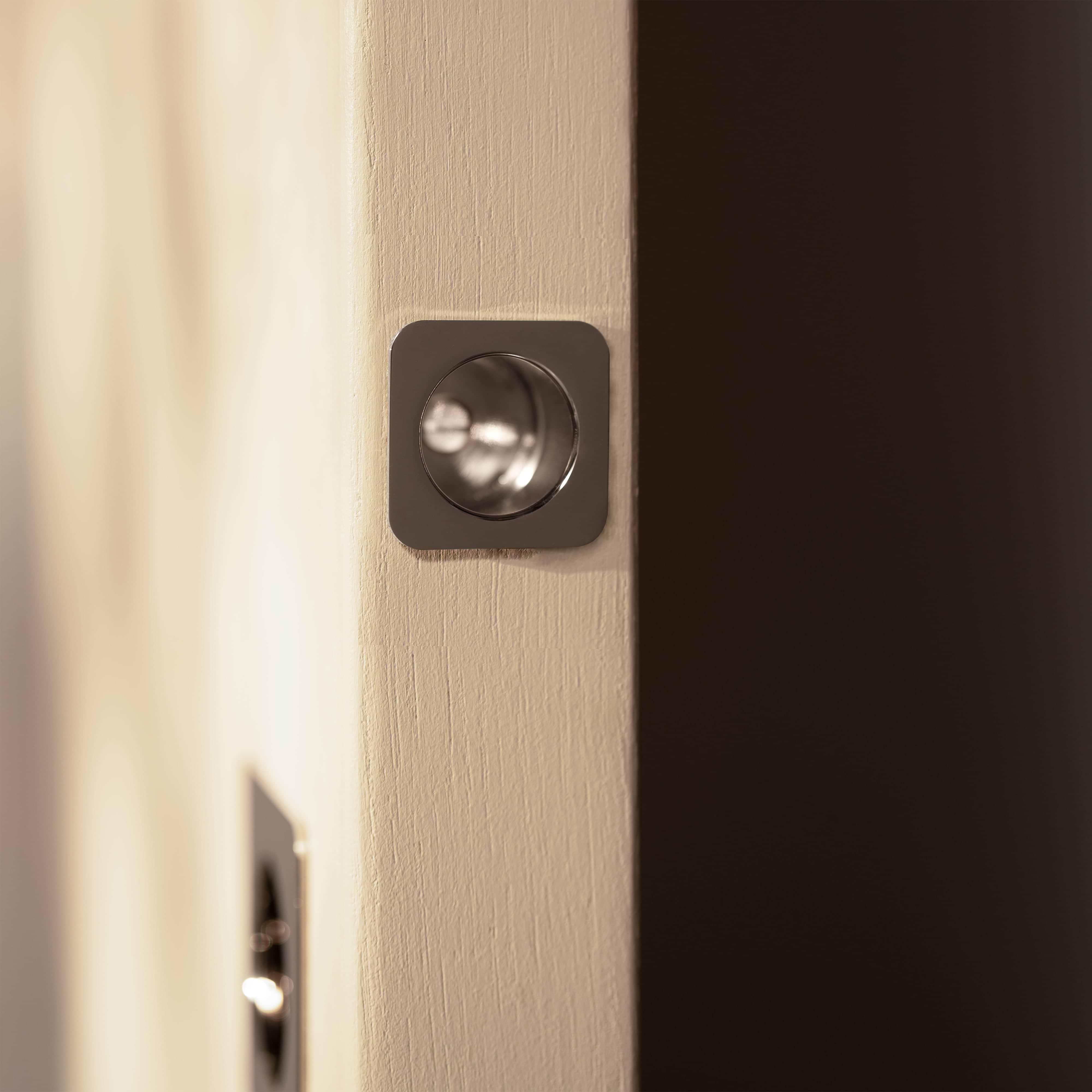 Regent Recessed Edge Pull in Polished Nickel installed on a beige door, showing its sleek metal design.