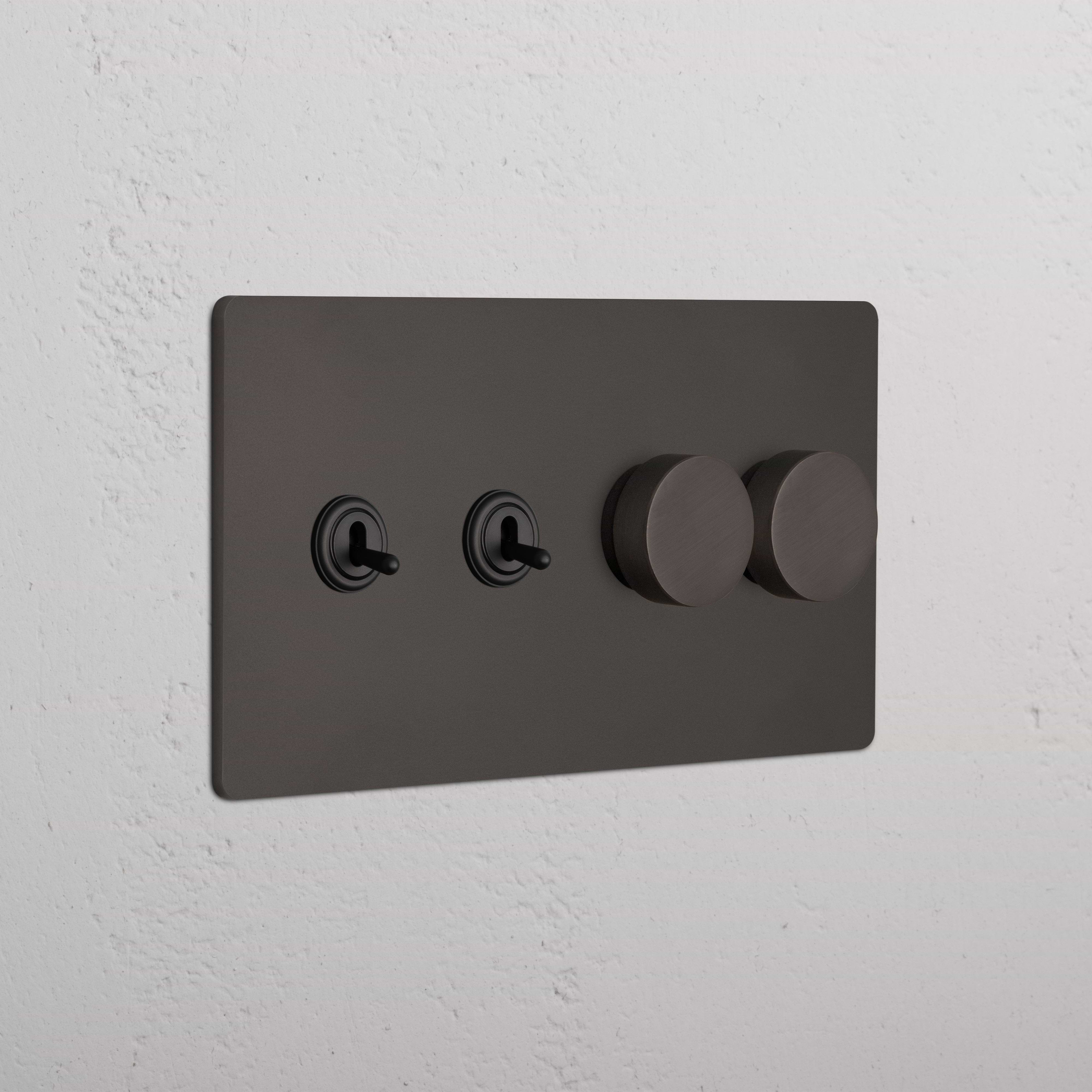 Bronze Grove 4G switch plate with two toggle switches and two dimmer knobs, mounted on a white wall.