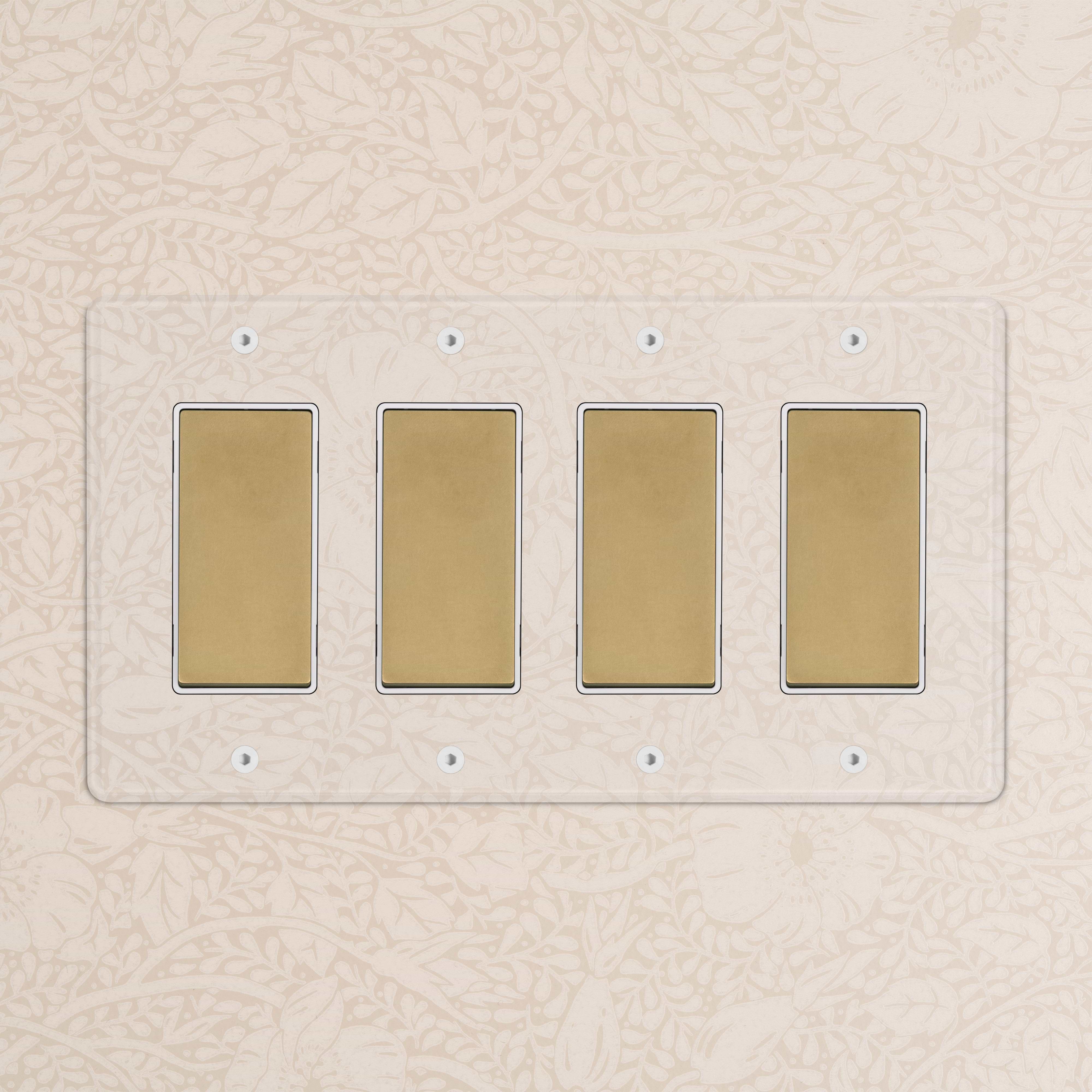 Kew 4G Rocker Switch in clear antique brass with four white switches on a decorative wall background.